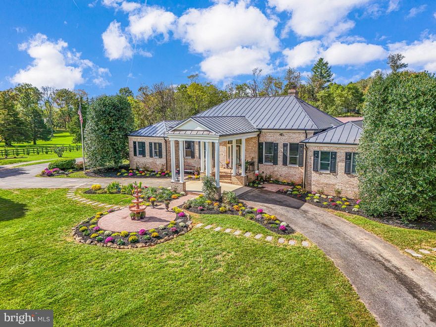 Located just over a mile east of historic Middleburg, Fox Hill Farm presents a rare opportunity to own a beautifully remodeled estate blending refined living with quintessential Virginia equestrian charm. Set on 7.6 picturesque acres, the property offers 6,547 finished square feet across the main residence and barn apartment, all accessed via paved and convenient Four Chimneys Lane off Little River Turnpike.

The elegant two-level brick home features a desirable main-level primary suite with a spacious walk-in closet incorporating a second laundry, along with two additional bedrooms, each with its own en-suite bath. A gracious foyer opens to formal living and dining rooms, while the expansive gourmet kitchen—anchored by a grand center island—flows seamlessly into a bright breakfast area and light-filled great room with a striking Palladian window framing views of the paddocks and barn beyond. A side-loading two-car garage completes the main level.

The recently finished lower level is an entertainer’s dream, offering a state-of-the-art home theater, recreation room, library/office, sitting room, full kitchen, wet bar, full hall bath, laundry, and two additional en-suite bedrooms. Walk-out access leads to a rear patio overlooking the landscaped grounds.

A separate driveway serves the fully remodeled guest cottage and barn, currently a sought-after short-term rental, complete with an oversized detached garage. Additional highlights include a fenced kitchen garden, outdoor gathering area, and potential for an accessory dwelling (subject to approvals). A truly special Middleburg retreat.