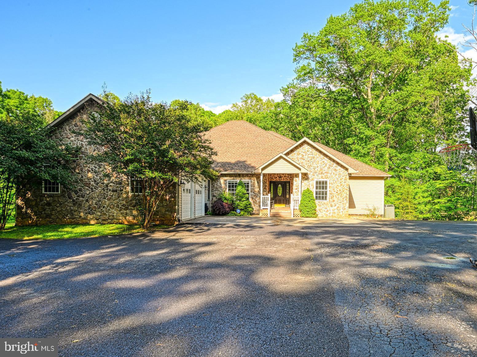 Rare 9.3-Acre Estate in the Heart of Lake Anna – Over 7,500 Sq Ft of Total Square Feet!
Welcome to 520 Oak Grove Drive—an entertainer’s dream and one of the most spacious properties available at Lake Anna. Situated on the public side and just minutes from Food Lion, Coyote Hole, the nursery, and Lake Anna’s main shopping corridor, this home is perfectly positioned for both convenience and privacy.
This stunning 6-bedroom, 4-bathroom custom home boasts over 7,500 total sq ft—with 3,790 sq ft on the main level and approximately 2,248 finished sq ft in the walkout basement. The exterior impresses from the start with a paved driveway and eye-catching rock façade. Boat slip is included!
Step inside to find an expansive floor plan with generous living and dining spaces. The main living area features a beautiful stone fireplace and an expansive kitchen with granite countertops and ample cabinetry—perfect for gatherings of any size. Just off the living room, a covered walk-out deck with tile flooring offers seamless indoor-outdoor living.
The main level offers 5 large bedrooms, a full laundry room, and direct access to the oversized 2-car garage. Downstairs, the finished basement includes a spacious second living room, a large 6th bedroom ideal for multiple beds, and big windows that bring in natural light and serene views of the backyard.
Enjoy the tranquility of 9.3 acres with room to roam, garden, or simply relax in nature. This home includes Lake Anna common area access—bring your boat, paddleboards, and guests! Boat slip #9 included located at the common area! Short-term rentals are allowed, making this an excellent investment opportunity or vacation retreat.
All of this just 1 hour from Richmond, Fredericksburg, Culpeper, and Charlottesville, and 2 hours from D.C. Properties of this size and location at Lake Anna are extremely rare—don’t miss it!