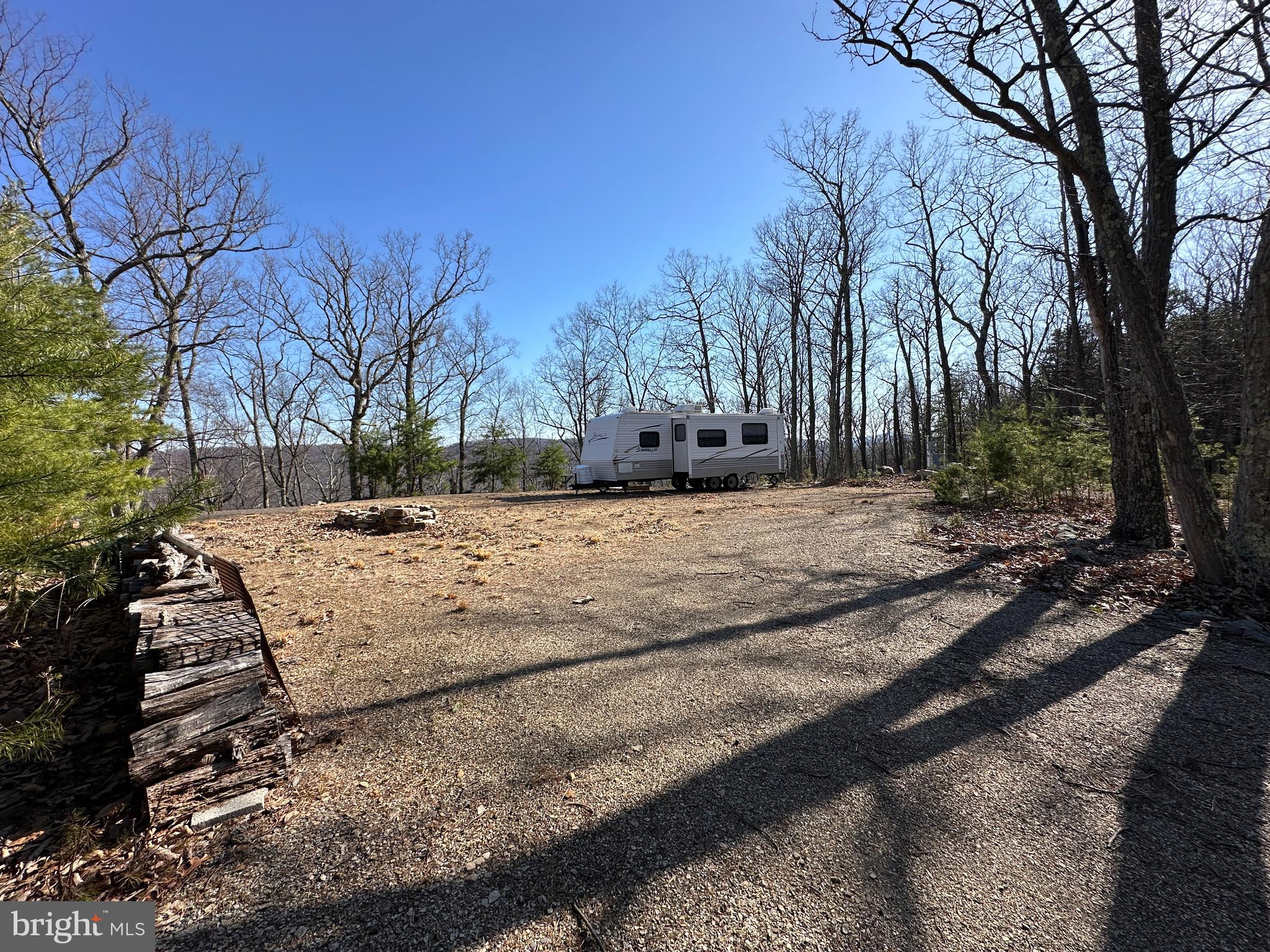 PRIVACY IN SPADES.....23 WOODED ACRES AT THE DEAD END OF THE ROAD ON A SECLUDED RIDGE OFFERING UNMATCHED PRIVACY AND THE VIEWS AREN'T TOO SHABBY EITHER. DRIVEWAY AND UNDERGROUND ELECTRIC INSTALLED TO BUILD/CAMP SITE, 20K WORTH OF INFRASTRUCTURE ALREADY COMPLETE! 2010 CAMPER CONVEYS AS A BONUS, YOU HAVE A PLACE TO STAY ON DAY 1. NICE HAND BUILT SHOOTING HOUSE OFFERING 200+ YARD SHOTS THROUGH THE HARDWOODS. ELEVATED AT 1350 FT WITH NEAT ROCK OUTCROPPINGS AND NICE LOGGING ROAD FOR ATV'S.....IT'S LIKE HAVING 2 LOTS IN ONE, THE TOP SIDE HAS THE BUILD SITE AND HARDWOODS, THEN IT SLOPES OFF THE MOUNTAIN TO ANOTHER DEVELOPMENT ROAD AT THE BOTTOM, THE BOTTOM SIDE HAS TOWERING LOBLOLLY PINES AND LAYS NICE. EASY ACCESS TO BOTH ENDS OF THE PROPERTY MAKES GETTING GAME OUT OF THE WOODS A BREEZE AND ALLOWS STEALTH WHEN ACCESSING STAND LOCATIONS SO YOU DON'T SPOOK ALL THE GAME OFF YOUR LAND. EASY TO GET TO BUT HARD TO FIND, IN AN ISOLATED UNDEVELOPED PART OF THE COMMUNITY, ONLY ONE HOME WITHIN MILES. LOCATED IN THE PRESTIGIOUS GATED COMMUNITY OF "THE BLUFFS ON THE POTOMAC".....THE BLUFFS IS KNOWN FOR IT'S ABUNDANCE OF BIG BUCKS, BEAR & TURKEY. AS AN ADDED BONUS, THE COMMUNITY HAS IT'S OWN PRIVATE COMMON AREA ON THE SOUTH BRANCH OF THE POTOMAC RIVER FOR CANOE, KAYAK, TUBES, FISH & SWIM......A PRIVATE PARK ON THE RIVER FOR YOUR SUMMERTIME ENJOYMENT. A UNIQUE LOT WITH MULTIPLE ATTRACTIVE FEATURES & BENEFITS. IF YOU'RE LOOKING TO DISAPPEAR AND GHOST THE WORLD...THIS IS THE ONE!
