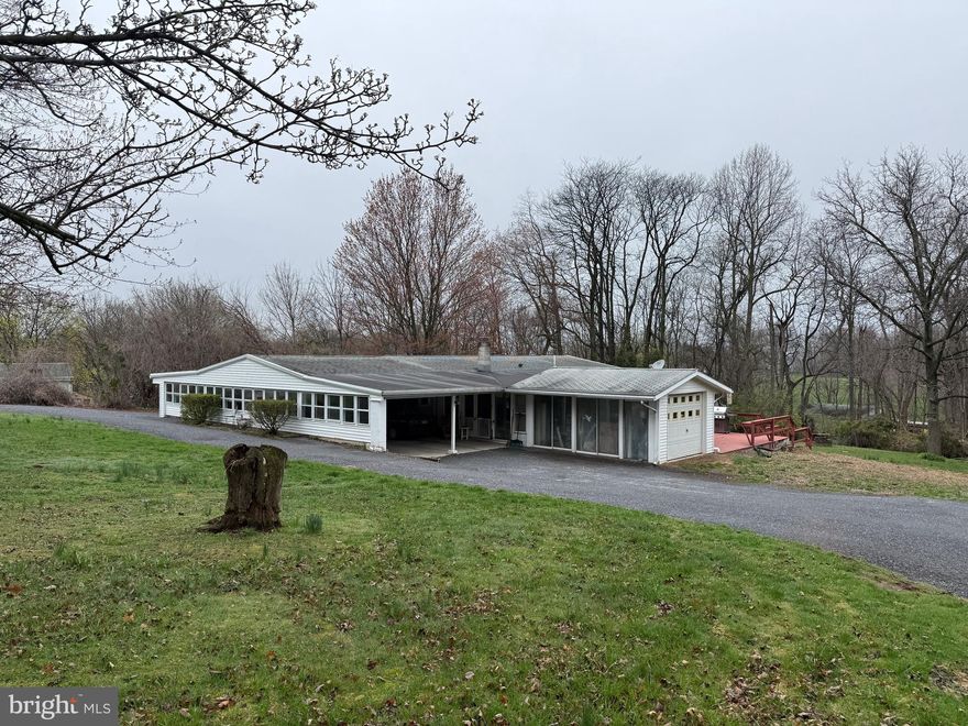 Welcome to 21 Crest Lane in Palmyra, a ranch-style home set on nearly an acre and packed with potential. This property offers a unique opportunity for buyers looking for space, flexibility, and room for hobbies, vehicles, or recreational toys. The property features multiple garage spaces, a large 4-car carport, and workshop areas, making it ideal for car enthusiasts, hobbyists, or anyone in need of extra storage and workspace. Inside, the home offers an updated kitchen with granite countertops, a center island, and a large dining area, all flowing into the nearby living room for a functional and open layout. The home includes 2–3 bedrooms, including a primary suite with a private full bath and walk-in closet. Additional features include a first-floor laundry room, pantry, and ample storage throughout. A sunroom provides a great space for seasonal enjoyment, while the large deck, complete with a hookup for a hot tub, offers great potential for outdoor relaxation and entertaining. The home does need some work, presenting an excellent opportunity to update and customize to your taste. With its spacious layout, versatile outbuildings, and desirable location, 21 Crest Lane is ready to be brought back to life. Bring your vision and make this property your own.