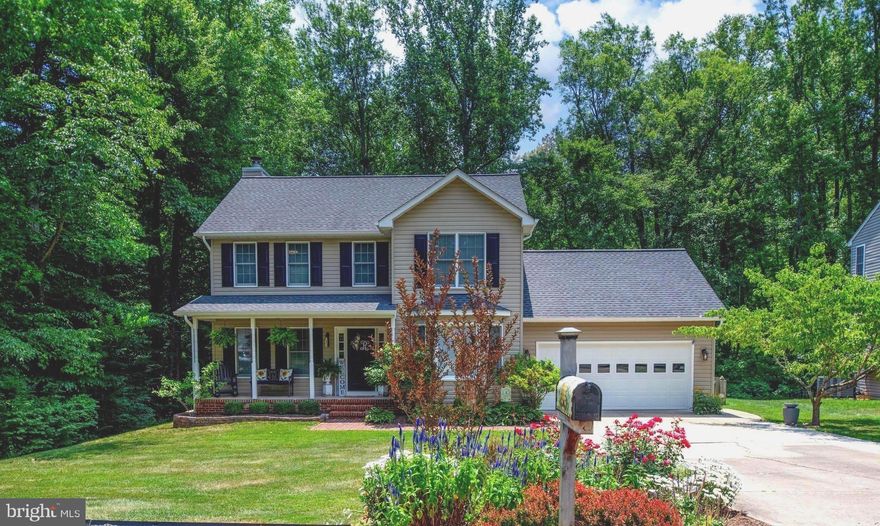 MOVE-IN READY, NO HOA!! This beautiful 4-bedroom, 2.5 bath home backs to trees and offers timeless classic charm throughout!  From the moment you drive up to this home, you are greeted with a manicured front yard, an extended driveway and a charming covered front porch, elevating its already striking curb appeal!  The main level boasts an adaptable office/living room, a family room with wood burning fireplace  opens to the eat-in kitchen, separate dining room, a convenient laundry room and half bathroom! Throughout this level, Luxury Vinyl Flooring seamlessly blends style with resilience, offering both aesthetic appeal and durability.  Throughout the home, upgraded contemporary lighting fixtures and ceiling fans, only adds to the refined style of this home!  The eat-in kitchen offers updated stainless-steel appliances, ample counter space, additional cabinets for increased storage, elegant glass-front cabinets, a pantry and more!  Upstairs discover 4 bedrooms and 2 full bathrooms!  The primary en-suite bedroom is spacious in size and features a large walk-in closet, while the primary bathroom offers a double vanity, separate shower and soaking tub!  From the family room and kitchen step directly out to your own private backyard oasis.  The fenced-in backyard offers woodland views and is a serene retreat  just waiting to be enjoyed!  Perfect for hosting gatherings or simply enjoying the outdoors, it features a 2-tier deck that leads to a covered gazebo where you can enjoy the gentle flow of water from the backyard water feature!  There is also ample open green space for various activities, cultivating a vegetable garden, tending to flowers or whatever works for you!  Extra wide driveway to allow for additional parking.  Other upgrades/updates of this home include: 2024 - New Interior Paint, Carpet. 2023 - New SS Refrigerator, Dishwasher. 2022 - Upgraded modern LVP flooring throughout main level.  Newer Roof, Gutters with Leaf Guard, Dual Zone HVAC System, Microwave and Stove.  Conveniently located near I-95/Rt 1/Rt 3, Shopping, Restaurants, Commuter Lot, Medical Center and so much more! NO HOA!  Move In Ready! Do Not Miss Out!