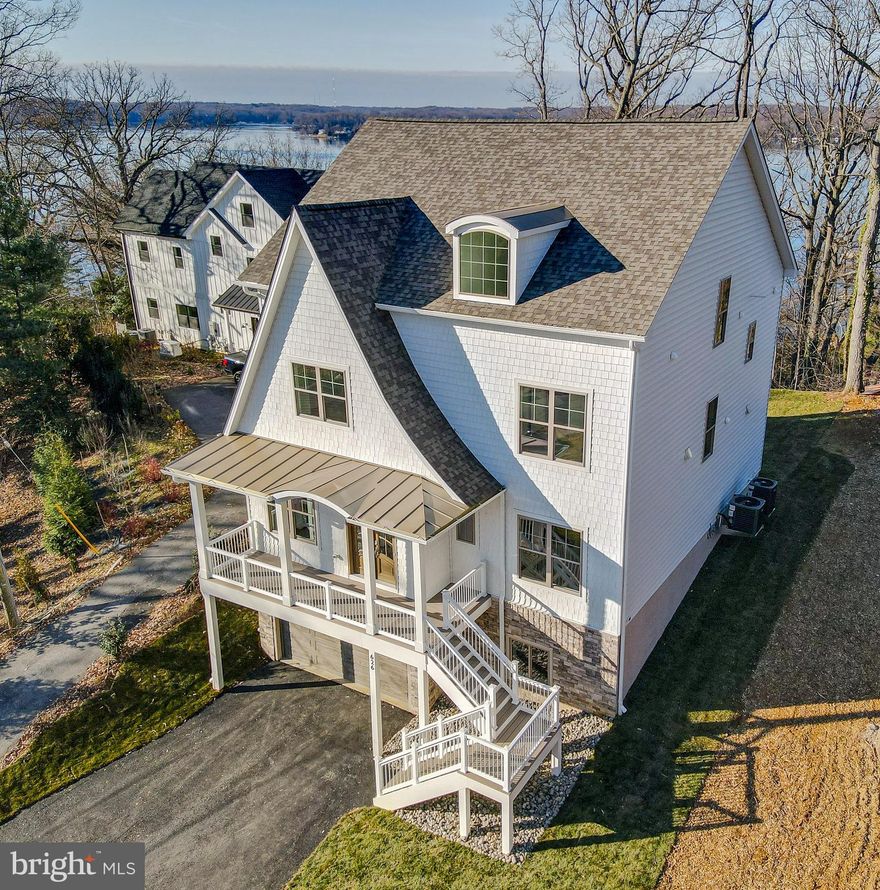 NEW CONSTRUCTION - Immediate Delivery! This luxurious and smartly designed 6 bedroom 4.5 bath brand new Modern Cottage Style house, has just been built in the highly desired community of Round Bay. Spanning nearly 5000 SF, this magnificent residence is graced by 10 foot ceiling on main level (and 9’ on the other 3 floors) feature gorgeous views of the Severn River from multiple vantage points. The deep front porch and the and the grand entryway draws you into a voluminous layout made for entertaining. Feel right at home on the Main Floor with an elegant Formal Dining Room, luxurious Chef's Kitchen with Large Island, a Great Room with a Cast Stone Fireplace and serve your guests at the Wet Bar with Wine/Beverage Fridge.  There is also a Private Office with Glass French Doors opposite a Full Bath with French White Oak Vanity, and an extra Flex Room you can make into a Mom’s Office, Study Room or Cozy Reading Room  A centrally located Elevator conveniently takes you to all 4 levels within the home. The next Floor starts with a divine Owner’s Suite where you can enjoy the expansive Sunset View of the Severn River from a Private Balcony, a generous Sitting Area, and an opulent En-Suite Bath with a soaking tub and a unique walk through shower. That floor is complete with two more large Bedrooms sharing a Jack & Jill Bath, and a Laundry Room.  The Loft Level showcases an Entertainment Room with another Wet Bar with Wine Fridge, and a Cozy Loft Sitting Area, where the family can enjoy the best western view in the house gazing through the glass doors that open to a large Roof Top Terrace on one of the the highest elevations in Anne Arundel County.  Another Bedroom and Bath complete that level. The Lower Level contains the 2-Car garage, a very large Recreation Room and another Bedroom and Full Bath.  Park your boat at one of the Two Marinas in the Waterfront Community of Round Bay.  You'll also love the convenience of being near it all!  Your children will attend exemplary Severna Park Schools, and the family can enjoy all the activities around and in the City of Annapolis, the Naval Academy, great dining, shopping and boating. Also near major commuting routes to D. C, Baltimore and the Chesapeake Bay Bridge.