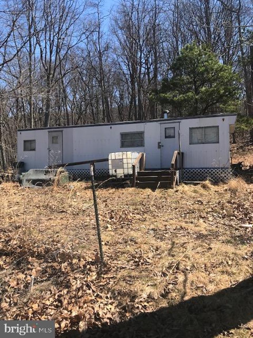 Rural 11.81 unrestricted acres with Mountain Views. This lot features a 320 square foot mobile home with electric. There is no well or septic on the property.  This lot is located off a country maintained road.  Come and enjoy this off the beaten path camping area.  Hunting allowed!