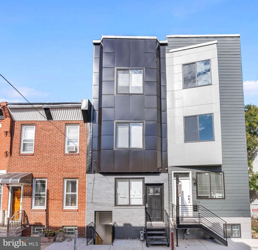 This newer construction, 3-story home has 4 bedroom suites with 4 full bathrooms, a finished basement with a separate entrance and a 5th full bathroom, 1 half bathroom, a private patio, and a roof deck. A quiet block, just off Grays Ferry Ave, leads to the towering facade. Inside the primary entrance, you're welcomed by an open and airy main level boasting modern floors, tall ceilings, and plenty of space to hang out or entertain. Past the powder room, there's a gleaming kitchen fitted with shaker cabinetry, stainless steel appliances, quartz counters, a tile backsplash, and breakfast bar seating. Out back, the fenced patio is ideal for summer barbecues and al fresco dining. The two upper levels each feature a pair of bedroom suites, set on opposite ends, with private full bathrooms. Topping off the home is an expansive roof deck showcasing mesmerizing views. An additional flexible space is the finished basement with its own private entrance, a full bathroom, and laundry. Utilities include central a/c, gas heat, and electric hot water. 3211 Latona St's convenient location provides easy access to public transit, Grays Ferry Ave, 34th St, and I-76. Plus, it's close to a popular shopping center with The Fresh Grocer and Wine & Spirits. Located just minutes from University of Pennsylvania, CHOP and other major hospitals, and the Philadelphia airport.  Schedule your tour today!