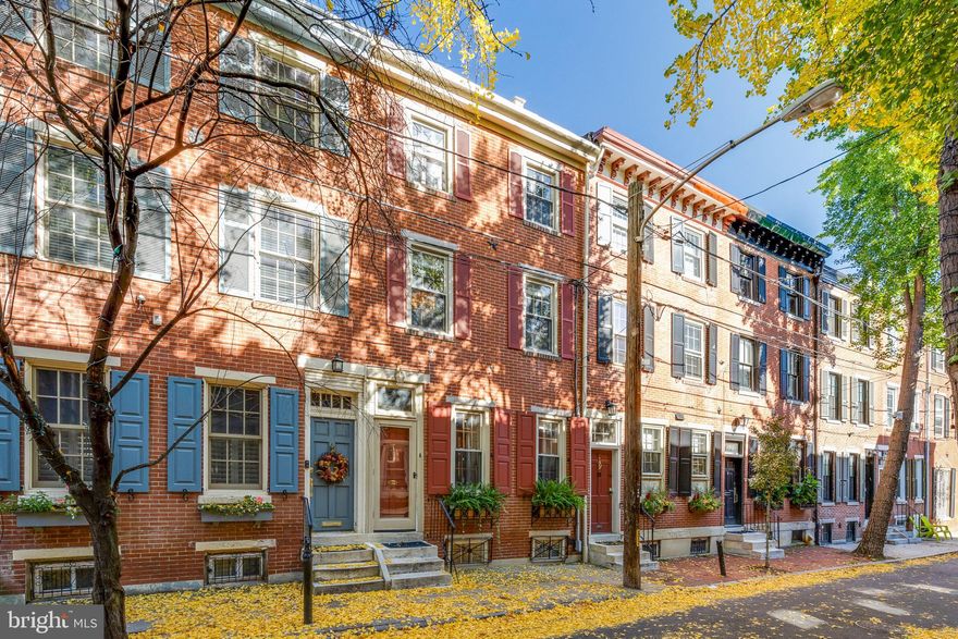 Loads of charm, classically styled and beautifully appointed 1709 Addison Street is now available for sale.  Fantastic opportunity to own a south facing townhome with a Private Deck, One Car Parking and all the enjoyment that comes with living on one of the prettiest blocks in Rittenhouse.  From the vestibule entry w/ full leaded glass door, you'll be taken into the formal Dining Room with magazine-worthy custom wood glass front cabinets surrounding the brick fireplace with ornate wood mantle.  Just beyond is the breakfast bar and kitchen that offers stone countertops, s/s appliance package and a super-sized pantry closet.  Access to the covered parking is just off the kitchen as well for added convenience.  The entire 2nd level of this home is the Living Room running from the front to back of the house at over 410 square feet.  Plenty of room to entertain and can accommodate multiple seating areas.  There is a wet bar perfectly situated at the slider glass door entrance to the large private trex deck off the back.  Deck features a retractable awning for longer outdoor enjoyment.  3rd level is the Primary Suite with exposed beam ceiling, plantation style shutters, and large closet.  From the hall you enter the full bathroom with a tub/shower and added storage.  There is also a laundry closet with stacked washer and dryer on this floor.  Fully finished lower level currently has the 2nd bedroom and half bath.  This level also has lots of added closets for storage.   The entire home is handsomely appointed with warm wood floors throughout set against wainscoting, crown moldings and brass accents and wall sconces.  Note that the 2nd level LR space had originally offered an additional BR and could easily be modified to accommodate that for the next owner.  Please view the attached Matterport tour and a floorplan has been included to showcase the amount of usable space should a buyer chose to reorient the current bedroom set up from the lower level to the 2nd level.  Easy to show by private appointment.