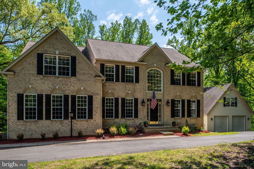 Country living with all the modern conveniences and no HOA. This spacious custom built estate checks all the boxes. 3+ acres of private wooded estate with 5 bedrooms, 4.5 baths, full finished basement, theater/workout room, open concept main floor, HUGE gourmet kitchen, attached 2 car garage and detached 2 car garage with loft. Have the best of both country life and city conveniences with endless possibilities. Featuring an open floor plan on the main level with beautiful skylights, large windows and open spaces. The kitchen features granite countertops, GE double oven, professional 5 burner gas cooktop, lots of storage in the wood cabinets, built-in buffet area to display your favorite items, dining room area, large pantry and laundry/mud room.  The main level also features the oversized living room with cozy fireplace, abundant natural light and HIGH ceilings, the formal dining room and living room and sizable office with french doors and a half bath. The dual staircase offers two options to access the top floor where you will find 4 large sized bedrooms offering flexibility and options. Three large bedrooms include one with a private full bathroom. The oversized primary bedroom features a sitting area, tray ceiling, walk-in closet and en suite bathroom with double sinks, soaking tub & walk-in shower. The lower level features a fully finished basement with a walk- out to the backyard and full bathroom. This large flex space with French doors to the back paver area also hosts  a full media/workout room and a HUGE oversized 5th bedroom with full size windows, walk in closet and plenty of storage. Home has a generator sub-panel wired, 50 AMP service for RV hookup. In addition to the attached 2 car garage, the detached garage can hold 3-4 cars or projects/boats/equipment and has a stairs accessible loft ready for your imagination. Newer roof, water system and a separate storage shed. Crow's nest nature preserve and canoe launch nearby. Home feels secluded but has high speed internet, grocery & meal delivery, 2.3 miles to Brooke VRE, short driving distance to: stores, restaurants, schools, I-95 express lanes, commuter lots. Schedule a tour today.