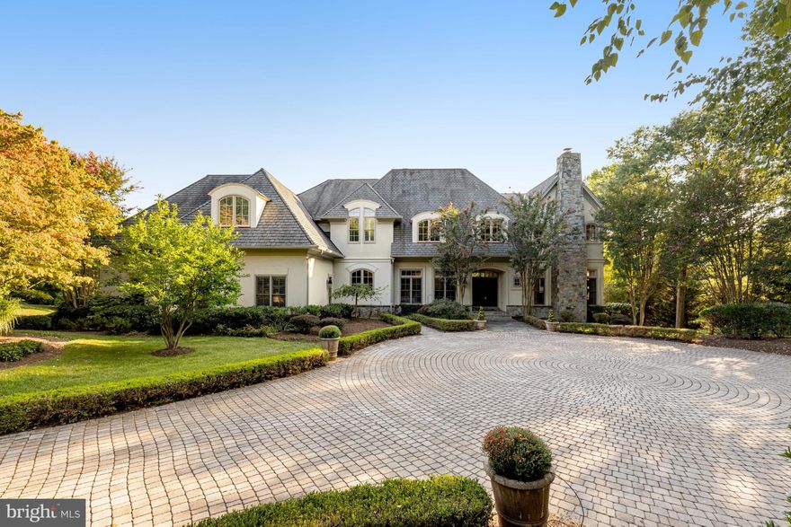 Great New Price! Custom-Quality Winthrop home with gorgeous heated pool located at the end of a quiet cul-de-sac (set well back from the activity of Georgetown Pike), perfectly sited on a private 5-acre lot. Serene setting, surrounded by trees and mature, professionally-maintained landscaping and extensive hardscaping - offering incredible views and privacy, in a convenient location - just minutes to 495, Tysons and downtown McLean. This impressive home, with 4 bedrooms, 4 full and 3 half baths and over 7,000 sq ft of living space, offers all the conveniences of how we live today. The main level feels open and airy, with high ceilings, gorgeous trim detail, hardwood floors throughout and an abundance of oversized windows. The thoughtful layout provides options for work-from-home lifestyles. Featuring a private home office with built-ins and direct access to the slate patio with steps down to the pool deck, a living room with fireplace, separate dining room and cozy family room with an oversized stone fireplace, and floor-to-ceiling windows on both sides offering direct access to the patio. The large eat-in kitchen has an incredible amount of storage and counter space with a large center island, as well as back stair access to the upper level, a large laundry room and additional main level ½ bath off the 3-car side-load garage. 

The upper level, with hardwoods throughout, has four generously-sized ensuite bedrooms, including the light-filled primary bedroom suite, with spectacular views of the property and a fireplace.  The primary bathroom has a separate walk-in steam shower and soaking tub, radiant heated floors, and a cedar closet. A large addition, added in 2005, with large sitting area, built-ins and a fireplace, offers multiple options for use as an alternate primary bedroom, 5th bedroom, home office, playroom, exercise room, study, craft room.... 

The finished lower level offers a large and comfortable rec room with fireplace and French doors with access to the slate patio, a wet bar, a home gym/yoga studio with a mirrored wall and sauna, a gorgeous wine room and plenty of storage space. 

Langley High School pyramid, immediate access to major commuter routes, minutes to high-end shopping, everyday conveniences, a variety of grocery stores and dining experiences, as well as parks and exercise facilities.