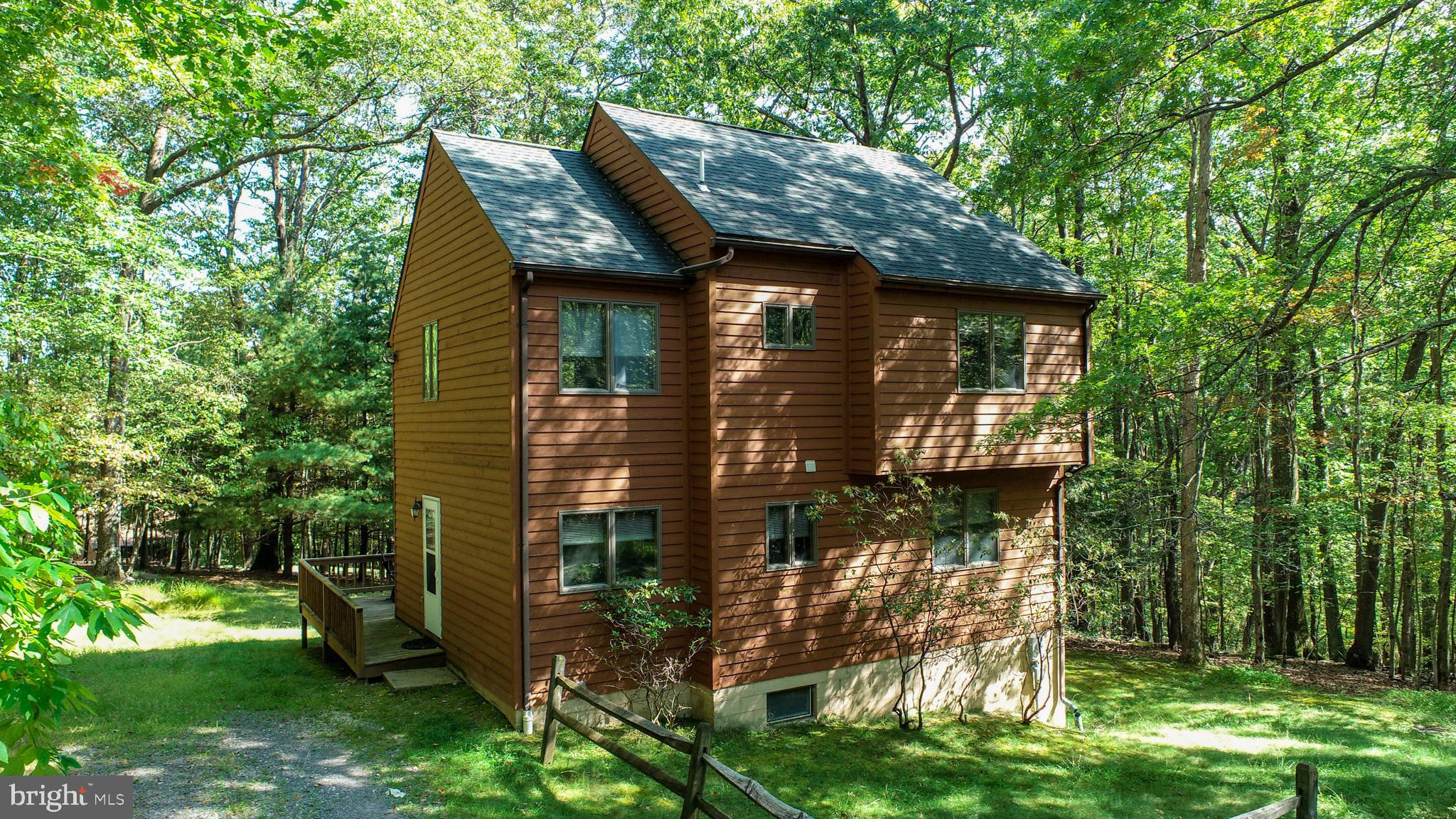 Don't miss this incredible opportunity to own a 3-bedroom, 2-bath home nestled on a spacious, wooded lot. Located in the serene lake-access community of Paradise Gardens, this property includes a dedicated dock slip, making it perfect for boating enthusiasts and lake lovers alike. Enjoy the great outdoors with expansive decks ideal for entertaining, relaxing, or taking in the tranquil wooded surroundings. Gather around the fire pit on cool evenings and create lasting memories with friends and family. Inside, cozy up tothe wood burning fireplace after a day summer or winter time fun . Downstairs the unfinished basement offers a blank canvas for future expansion — whether you're dreaming of a game room, guest suite, or home gym. There's also extra storage space to keep things organized. Whether you're looking for a year-round residence or weekend retreat, this home checks all the boxes. Schedule your showing today and take the first step toward lake living!