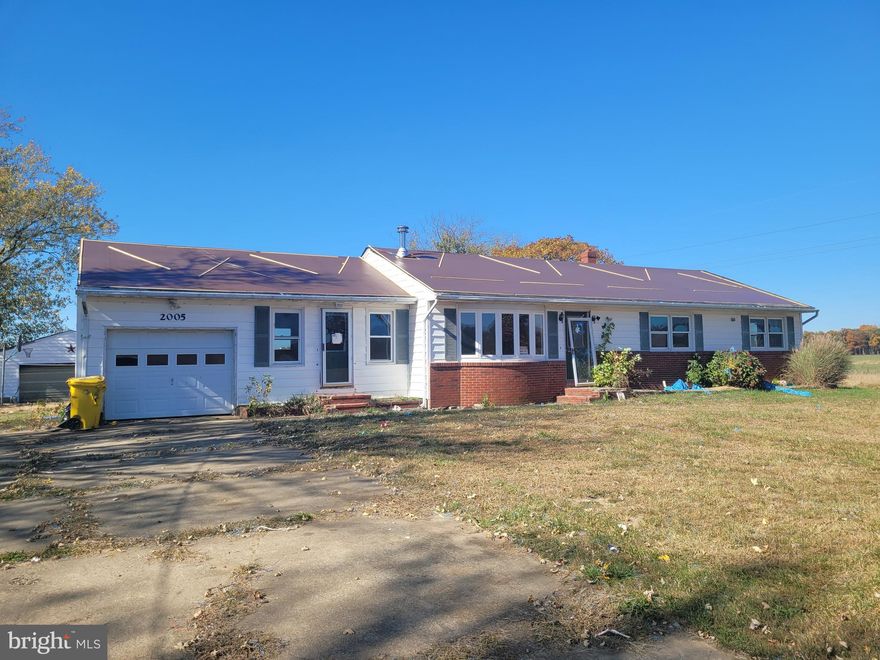 Sprawling ranch home on a country acre surrounded by farmland views.  Large kitchen opens into dining area and formal living room with wood burning stove.   Den area connects home to attached garage.  Full basement with walk out steps to the exterior.   Large detached garage for hobbies, and paved concrete driveway.  Come with vision and a plan, and make this house your home!