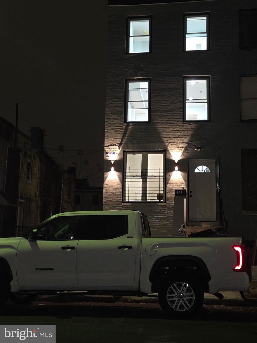 **Beautifully renovated 4-story end-unit Federal-style row home** featuring 3 bedrooms and 2 full baths and one half bath. This home offers hardwood floors throughout, quartz countertops, soft-close cabinetry, recessed lighting, and electric fireplaces in both the living room and primary suite. The main level includes a half bath and access to a newly built balcony with privacy panels. The second-floor primary suite features an ensuite bath, walk-in closet with built-ins, and a private balcony. The third floor includes two additional bedrooms with wardrobes and a full bath with a silent exhaust fan. Enjoy a private fenced backyard and a separate exterior entrance to the basement. Home includes updated fixtures, an alarm system with a security door, and high-end finishes throughout. Sellers also own the adjoining property and will be fully renovating it as well, improving the entire streetscape. Move-in ready in a convenient Baltimore City location.