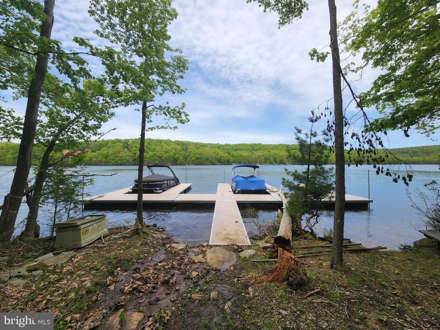 Rare offering! LAKE VIEW building site with TWO BOAT SLIPS! Located off popular Lake Shore Drive in the Edgewater community, this lot features a building envelope surrounded by community green space. Deep water, somewhat flat area by the lake, feels like small little park area. Dock access is directly across the street and a short walk away away - 100 yards +/-. Paved parking area for easy unloading and is also ATV/golf cart friendly. Lot #4 is part of a 6 lot landominium concept where you own the building site and the home built on it but there are limited common areas surrounding all properties.