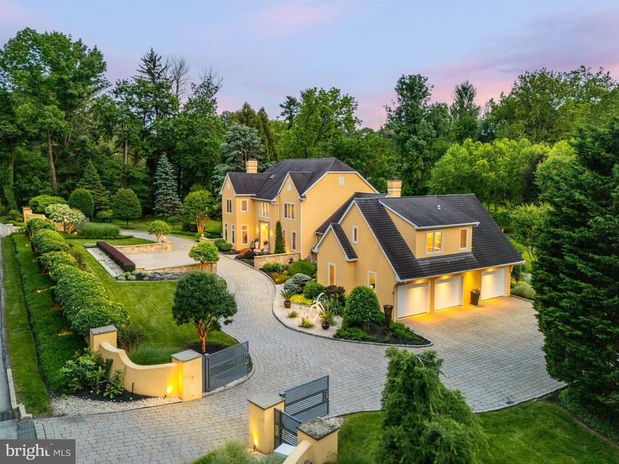 A walled enclosure set back behind custom Designed Gates by Compass ironworks, you enter a landscaped courtyard with a Circular Driveway, where sculptural crimson barberry hedges, river rock beds, and Japanese kousa dogwoods welcome you like a living painting. Each step toward this 2-Acre property reveals another layer of design intention. Twin custom oak doors, set within a tailored precast concrete façade by CDI of Tucson, signal the threshold to something special. 
Designed by acclaimed architect Mark Stanish at Michael Visich Architects, this residence is a rare find for connoisseurs of modern design and lovers of peace. Inside this approximately 6,000 SQFT of living space, the foyer immediately immerses you in the home’s warmth and artistry, from finely crafted woodwork to sophisticated designer finishes. To the left, the Formal Living room features a Gas Fireplace, glowing against California-sourced Kreiss furnishings. Nearby, a polished Bar invites guests to linger before continuing into the home.
The Formal Dining room, with a round table centered on Italian tile and framed in South African slate, feels as though it opens directly to nature. Floor-to-ceiling glass doors offer a view of a gentle stream, drawing the outdoors in. The dining space flows seamlessly into the heart of the home - a Gourmet kitchen imagined by Tina Krinsky, celebrated as one of the Main Line Masters. Every detail here balances functionality with grace: Custom Cabinetry, a Fisher & Paykel Two-drawer dishwasher, sleek countertops, and a Built-in refrigerator anchor the space. A Built-in Window Bench offers the perfect perch for reading as snow settles over the sculptures just beyond. The adjoining Buffet area houses a custom Wine Cooler and ample storage, while a sunlit dining table seats 6 to 12, surrounded by garden views.
After a celebration, guests can gather in the Great Room for coffee beside the fire. Wherever you are, the kitchen, living room, dining room, glass doors beckon you outside to the expansive travertine terrace, imported from Turkey, which wraps around the rear of the home. Measuring 75 feet by 16 feet, this outdoor gallery space includes multiple seating zones and a fire table. The crown jewel is a custom Allison Armour sphere fountain imported from England. To the right, a private Jacuzzi nestles beneath a lush trumpet vine arbor. 
Just beyond is a breezeway leading to a fully-appointed Guest Suite, complete with its own kitchen, dining room, living room, and bedroom, acts as a peaceful, self-contained retreat. Adjacent to the suite, a spacious Three-car Garage offers custom cabinetry with abundant storage. Returning through the arched breezeway to the main house, you pass a Powder Room and Laundry Room before ascending the grand white oak staircase. Upstairs you'll find Three bedrooms, Two Bathrooms with Velux skylights, and a refined Home Office with Built-in his and her desks. Double doors open to a serene Primary Suite, a haven, featuring a Spa-inspired bathroom, an expansive California Closet system with Glass Doors, a second washer-dryer, and views over lush, mature gardens. Secondary bedrooms are filled with light and boast generous closets. Finished Lower level offers a Living Room, Full Bath, Gym, Craft Room, Cedar closet, Office space with a Built-in desk, wine storage and even more to discover.
Once you enter the grand circular driveway, behind the wall, through the gates, this home reveals new layers of beauty. All you hear is birds chirping with the ever-changing landscape. Seller has plans available from an in-ground pool. Situated on lush 2 acre grounds this beauty is a rare find in Radnor township!

This magnificent property comes furnished (exclusions apply) & has been meticulously updated w/new state-of-the-art mechanical systems including  Generator, Sprinkler System,  Hunter Douglas Motorized Shutters, 
Electric Car Charger and many more amenities.