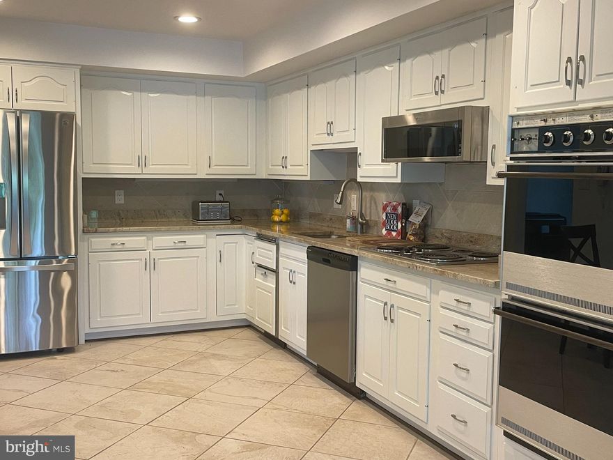 Welcome to Sumner Village, where luxury meets convenience.  Situated in a sought- after location in Bethesda, this condo offers a perfect blend of style, comfort, and convenient living. Rarely available, this is an “03” corner unit floor plan, all one level, no steps with 3 bedrooms, 2.5 bathrooms, high ceilings and large windows that let in plenty of light.  Enjoy the custom details including a large arched pass through from the kitchen to the living room allowing for a more open feel while still having dedicated space to both.  Notice the recently replaced modern mantle over the woodburning fireplace in the living room. 
The bright open living space has large sliding doors that open to a spacious balcony.  Flowing around to the side is a separate dining space with balcony access as well.  The large kitchen has granite counters, freshly painted cabinets and stainless-steel appliances with plenty of space for a breakfast table.
This property has privacy with the bedrooms on the other side of the living spaces.  There is a bedroom/ den or home office with hardwood floors, a second bedroom with ensuite bathroom and the primary suite with built-in dresser drawers and dressing area, a walk- in closet, vanity with large mirror and full bathroom.  
Other highlights include a powder room for guests, in unit laundry, stunning crystal chandelier, custom window treatments, recessed lighting and more! 
**2 parking spaces available to rent with potential to purchase. 
The building amenities include a guard gate with 24- hour attendance, a pool, tennis courts, pickleball courts, fitness center, a community room and much more. This condo is located within walking distance to the Shops at Sumner Place, Starbucks, Safeway, restaurants, beautifully landscaped green spaces, and walking paths.