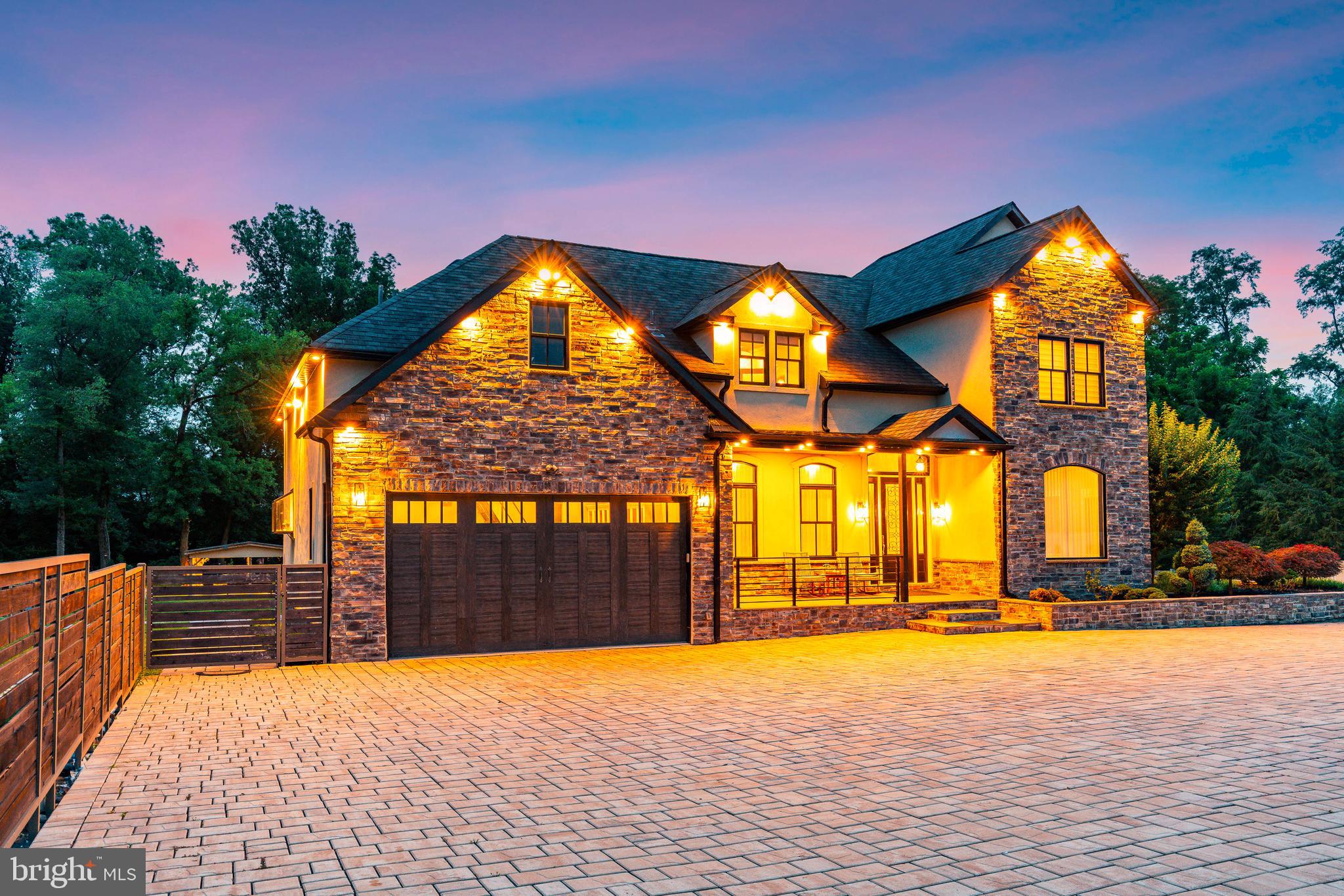 Welcome to one of the most extraordinary properties Philadelphia has to offer. An impeccably designed, over 12,000 sq. ft. residence that seamlessly blends timeless elegance with modern sophistication. Situated on a private lot, this five-year-old custom estate offers unmatched craftsmanship, luxury amenities, and thoughtful design at every turn.
As you approach, the expansive paver driveway sets an impressive tone, leading to a two-car attached garage and offering ample parking for guests. This striking entrance is just a preview of the grandeur that awaits inside.
Step through the grand double doors into a dramatic vaulted foyer adorned with gleaming marble floors and bathed in natural light. To your right, a beautifully appointed office with newly refinished hardwood floors offers the perfect work from home space, while to the left, a spacious formal dining room features a stunning tray ceiling and rich hardwoods, ideal for hosting elegant dinner parties.
The heart of the home lies in the expansive great room, where soaring two-story ceilings, hardwood floors, and a striking electric fireplace with stacked stone surround create a warm, inviting ambiance. Glass doors lead out to a composite deck that overlooks the home's backyard paradise, an entertainer’s dream.
The chef’s kitchen is truly a showstopper, boasting a massive island with waterfall-edge quartz countertops, a Viking six-burner range, wall oven, Viking refrigerator, wine fridge, and a spacious breakfast nook. A walk-through butler’s pantry with custom cabinetry and matching quartz countertops connects the kitchen to the formal dining space, offering both style and function.
The first floor primary suite is a true retreat, featuring tray ceilings, hardwood floors, recessed lighting, and private access to the rear deck. Two custom walk-in closets provide ample space, and the spa-like en suite bath stuns with a double vanity, soaking tub, oversized walk-in shower, a separate steam shower, and a dedicated makeup vanity, a personal oasis designed for relaxation.
The main level also features 10-foot ceilings throughout and a stylish half bath for guests.
Ascend the illuminated staircase to find 4 generously sized bedrooms and 3 full baths. Two of the bedrooms offer en suite bathrooms, while the remaining two share a beautifully designed hall bath. Each bedroom is tastefully finished with updated flooring, recessed lighting, and thoughtful details. For movie lovers, the second floor also includes a dedicated theater room, perfect for cozy film nights or entertaining guests in cinematic style.
The lower level is its own private sanctuary, boasting 9-foot ceilings, recessed lighting, and walkout access to the stunning backyard. This space includes a full eat-in kitchen with quartz countertops, an electric fireplace in the secondary living area, and a large laundry room with abundant cabinetry, counter space, and a utility sink. The basement features two bedrooms, each with its own attached bathroom, and a beautifully tiled half bath for guests. The en suite bathrooms are luxurious, with features like pebble-stone shower, rain showerhead, and premium tile finishes.
Outside, the backyard is nothing short of a dream. A spacious covered paver patio is ideal for alfresco dining, while the elaborate outdoor kitchen makes entertaining effortless. A custom treehouse, fire pit area, and beautifully landscaped grounds complete the setting, offering a true resort-like experience at home. Don’t forget the charming outhouse with an additional half bathroom for added convenience.
Every inch of this home was thoughtfully designed with top of the line upgrades and meticulous attention to detail. From the extensive trim work to the designer lighting, smart home systems, and luxury finishes, this property offers a lifestyle rarely found in Philadelphia.