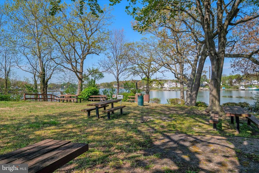 Welcome to 1195 Annis Squam Harbour—where life doesn’t just happen, it unfolds along the water. Located in Elizabeth’s Landing, one of Pasadena’s most sought-after waterfront communities, this is the opportunity buyers wait for—private beach access, a fishing pier, boat ramp, and sunsets over Stoney Creek just moments from your front door. Inside, the home delivers immediate impact with rich hardwood floors spanning the entire main level and a layout that flows effortlessly from the sunlit living room into a dining space finished with elegant chair rail and shadow box detailing. The kitchen is crisp and functional with 42” cabinetry, stainless appliances, designer countertops, and classic tile backsplash, opening directly to a large deck overlooking a fully fenced backyard—ideal for entertaining, letting the dogs run, or unwinding at the end of the day. The walk-out lower level adds real versatility with a spacious rec room, full bath with walk-in shower, and dedicated laundry area, creating the perfect setup for guests, work-from-home, or additional living space. Upstairs, the primary suite offers a walk-in closet and direct access to a dual vanity Jack-and-Jill bath, while two additional bedrooms provide generous space and flexibility. This is not just a townhome—it’s a lifestyle play in a community people rarely leave, where boating, beach days, and easy access to Annapolis, Baltimore, and major commuter routes come together seamlessly. Opportunities like this do not sit—schedule your showing before someone else claims it.