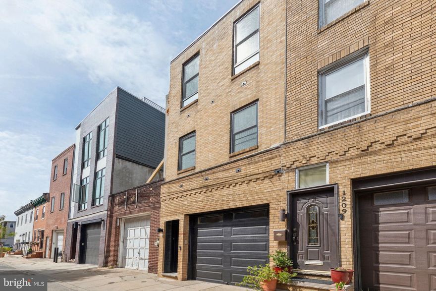 Welcome home to this stunning, unique, industrial-chic townhome with coveted GARAGE parking on a quiet block in the heart of Passyunk Square. Step out of the bustle of the city and into your tranquil oasis, featuring beautiful solid oak hardwood floors, high ceilings, exposed duct work, recessed lighting, ceiling fans, newer HVAC (2022), and endless natural light. The kitchen boasts leathered granite countertops, stainless steel appliances, 42” cabinetry, and a sleek subway tile backsplash. It opens seamlessly to the sunny dining and living room, perfect for entertaining or relaxing. The bedrooms are spacious with abundant closet space and numerous built-ins. Both full bathrooms are beautifully finished with stone floors in the showers and tile backsplashes. Need an ensuite for guests? The downstairs bedroom features a full closet and full bathroom of its own for the privacy and separation a guest may desire. Grab a drink at the wet bar and wow your guests with the incredible city skyline view from the newly-refinished ROOF DECK. With a WalkScore of 95, you are just steps away from restaurants, shops, cafes, gyms, grocery stores, and the Italian Market. The Broad Street Line is just two blocks away, providing easy access to both Center City and the stadiums. Your dream home awaits!