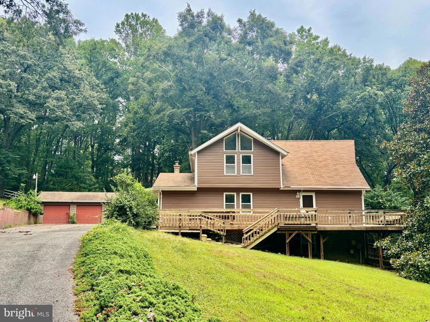 A contemporary retreat near the Port Tobacco Waterfront! Discover over 2,500 sq ft of total living space in this charming 3-bedroom, 3-bathroom home, set on a peaceful 2.73-acre lot surrounded by mature trees. Located just minutes from the Port Tobacco waterfront and marina—and a short drive to La Plata’s shopping, dining, and conveniences—this property offers the perfect blend of privacy and accessibility. Step inside to a warm, rustic atmosphere with hardwood floors throughout the main and upper levels, complemented by rich wood paneling and gorgeous wood soaring ceiling in the great room that creates a ski chalet feeling. The galley-style kitchen offers an abundance of counter space, ideal for meal prep and entertaining. A full bathroom is located on each level, and the each bedroom, including the main level bedroom features dual closets for ample storage. The finished basement features a full bathroom, storage/mechanical room and a bonus room with a built in bookcase all together with a gathering room that boasts a free standing wood stove. Car enthusiasts and hobbyists will love the oversized 3-car detached garage with plenty of room for vehicles, tools, and work benches. Two additional sheds and a lean-to off the garage provide even more storage options for equipment and projects. Enjoy the outdoors from the expansive wraparound deck with scenic views of the gently rolling landscape. Whether you're an investor seeking a promising fixer-upper or water-friendly rental, or a first-time buyer looking to build sweat equity, this property offers incredible potential in a truly serene setting.