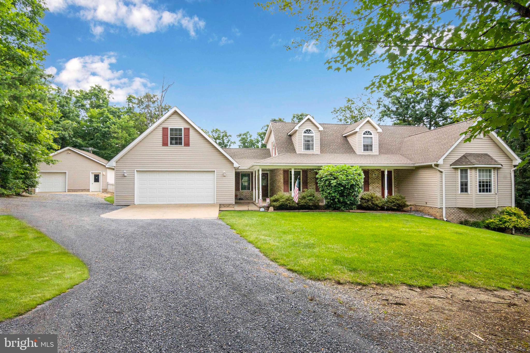 Tucked away at the base of Little North Mountain, just outside of Strasburg, this beautiful country "Home" offers space, privacy, and comfort on 6.25 wooded acres. This spacious home welcomes you with a covered front porch and is nestled in a peaceful setting just off Pontzer Road in the Mt. Olive area. The main level features hardwood floors throughout, a open-concept updated kitchen with quartz countertops. The family room has a cozy gas fireplace, and the formal dining room is perfect for gatherings. The sunroom off the kitchen—with walls of windows and hardwood flooring & skylights—opens to a screened-in porch with sliding windows, ideal for enjoying nature & trees year-round. The main-level primary suite offers a cozy get away with an updated en-suite bathroom featuring a walk-in shower, double sink vanity and ceramic flooring. A laundry and half bath are conveniently located on the main floor as well. On the Upper level you'll find two additional bedrooms, a full bath, a cozy sitting area, and a bonus room that’s perfect for an office, nursery, or hobby space. Above the oversized two-car garage is a finished bedroom ideal for guests or a private retreat. The walk-out lower level is fully finished and includes a spacious family room with a gas stove, a full bath, and two bonus rooms that have been used as guest bedrooms—perfect for hosting family or friends. Outdoor living shines with a large deck, patio, and scenic wooded views. An additional detached 1-car garage with a storage or workshop area adds even more versatility. Whether you're looking for a peaceful or a secluded residence close to town, this home offers the best of both worlds—country charm and modern comfort just minutes from Strasburg.