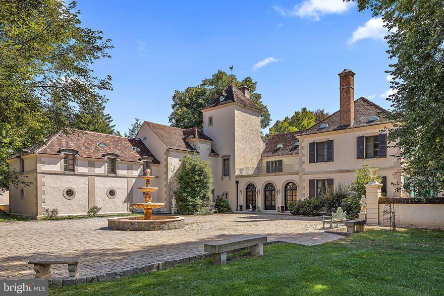 Chevannes, an exceptional estate in Delaware’s Chateau Country, was originally built for the first wife of Alfred I. du Pont, Bessie Gardner du Pont. Bessie had a close relationship with Alfred’s family and his cousins Pierre S. du Pont and H. Rodney Sharp assisted her in securing the land and planning the construction of the home in 1926. Albert Ely Ives was the renowned architect of this beautiful home. Said to be based on the original du Pont French homestead, Bois-des-Fosses, near the village of Chevannes, France. Nestled on a private 7+ acre parcel directly across from Winterthur, this home shares the same architect as its esteemed neighbor.
The stately home was built using stucco over solid masonry with limestone quoined corners. The residence is a testament to construction of the time with graceful proportions and exquisite architectural detail. Featuring 6 bedrooms, most with en-suite baths, and formal rooms that characterize grandeur. A walnut-paneled living room and a grand foyer reminiscent of great French homes welcome guests into a stately dining room adorned with two marble fireplaces. An expansive pantry with the original walk-in silver safe connects the dining room to a spacious kitchen. French doors open to expansive terraces overlooking formal gardens, an in-ground pool, and a 3-car heated garage.
Showcasing their dedication to details, chestnut seeds were brought from the Bois-des- Fosses estate to create an allee on the grounds that still remains. A walled brick paver courtyard creates a stunning garden. At the time of construction, this enclosure was a rose garden that was inspired by a similar rose garden at Bois-des-Fosses. The current owners added an al fresco dining garden with wood burning fireplace along with making numerous functional improvements including an internal guttering system, upgraded HVAC system, house generator, and impressive custom electric gates leading to a new driveway including the Belgian block lined circular drive court. Don’t miss your opportunity to own this stunning example of early 1900’s architecture and a piece of Delaware history.