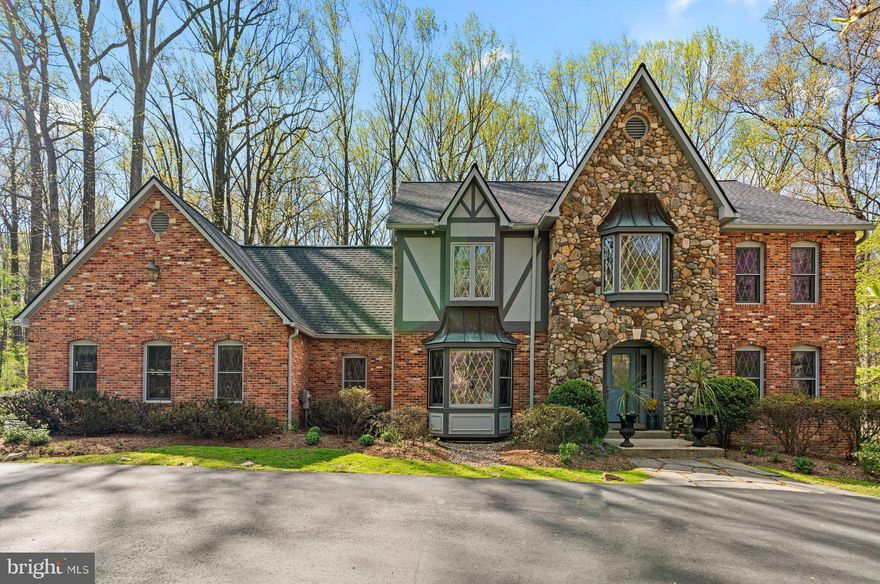 Step out of a storybook and into your dream home. Tucked away on a private, picturesque 5-acre tree-lined lot, this showstopper will leave you speechless with every turn. Take a minute to appreciate the serenity this home's location offers as you stand on the front porch underneath the arched-stone entryway. Inside, you will notice a unique sense of style, true to this home's architecture. Wooden trim, hardwood floors, creamy paint, and classic details throughout! The formal living room offers endless possibilities. Don't miss the office/den, which makes the perfect spot to work from home; tree-lined views from every angle! The family room is the perfect space to entertain. Floor to ceiling stone fireplace, arched window and door detail, stunning woodworking, and sight-lines straight into the fully renovated and gorgeous kitchen. No expense was spared during this kitchen renovation. High-end cabinetry, massive island, stainless appliances, and a workflow that chefs dream of! Room for a kitchen table, or take advantage of the spacious dining room with spectacular bay window. Upstairs you will find 4 massive bedrooms. The primary suite is the definition of luxury with it's own fireplace, dressing area, walk-in closet, and expansive en-suite bathroom complete with a soaking tub, dual vanity, and walk-in shower. The basement has been completely renovated and is fully fitted as a separate apartment or just an amazing entertaining space. Two additional bedrooms, a full bath, second kitchen, and walk-out doors to the stunning backyard. Options for use include an au-pair suite, in-law suite, accessory rental apartment, the opportunities are truly endless. The backyard oasis is the cherry-on-top, with a fully covered gazeebo, large deck, and additional patio below, you will feel like you are miles outside of town while being minutes from everything Olney/Brookeville/Ashton has to offer. You won't want to miss this one, so call us for your private showing TODAY!