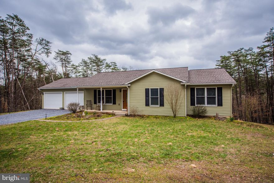 Tucked on a wooded lot, just minutes to downtown Berkeley Springs & Interstate 70. One level home features wood floors, laundry off kitchen through pocket doors, and solid wood doors. Spacious, home with 3 Bedrooms and 2 Baths. Full walkout basement 1/2 carpeted, with rough in for bath. 2 car attached garage plus a shed for lawn/garden tools.  Move in ready!  Get ready for quiet & privacy.
