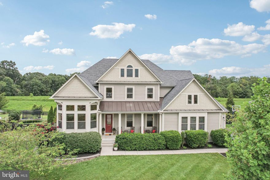 Major Price Improvement! Welcome to 25842 Yellow Birch Road, a rarely available Great Falls model in the coveted Greens at Willowsford—one of the largest floor plans in the entire community. This expansive home offers over 7,000 square feet of living space on an oversized 18,000 sq ft lot, backing to protected conservancy land at the end of a quiet cul-de-sac. With 6 bedrooms, 6.5 bathrooms, and a 3-car garage, it’s ideal for those seeking generous space, flexibility, or multigenerational living.

Step inside to find 10-foot ceilings throughout the main level and an impressive 12-foot ceiling in the living room, complemented by coffered detailing and wide-plank, hand-scraped hardwood floors. The gourmet kitchen is a showstopper with dual islands, upgraded cabinetry, and seamless flow into the sun-drenched morning room and expansive family space, with direct access to the covered patio. A spacious main-level bedroom suite adds flexibility for guests or multigenerational living.

One of the home’s most distinctive features is the massive mudroom/secondary prep kitchen off the garage—thoughtfully designed with abundant storage and functionality, ideal for busy households. Outdoor living is just as impressive, with a covered rear porch and patio surrounded by mature trees and peaceful views.

The fully finished walkout basement includes an additional bedroom and full bath, a home gym, two wet bar rough-ins, and ample storage space, offering endless possibilities for entertaining and daily life.
Enjoy resort-style amenities including pools, a splash pad, fitness center, lodge, dog parks, playgrounds, and even a treehouse—all with access to 250+ acre Hanson Regional Park, local farmers markets, and nearby Dulles Airport. With convenient access to Tysons, DC, the Silver Line METRO, and top-rated Loudoun County schools, this home offers the best of Northern Virginia living.