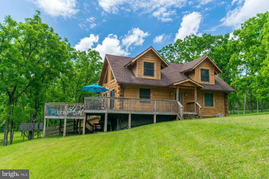 WEEKEND RETREAT OR FULL TIME LIVING. Rustic water front log home on 5.21 open and wooded acres plus large stocked pond, beautifully landscaped lawn and featuring two bedrooms two baths with loft overlooking great room, multi level deck and screened porch on full walkout basement in gated community.