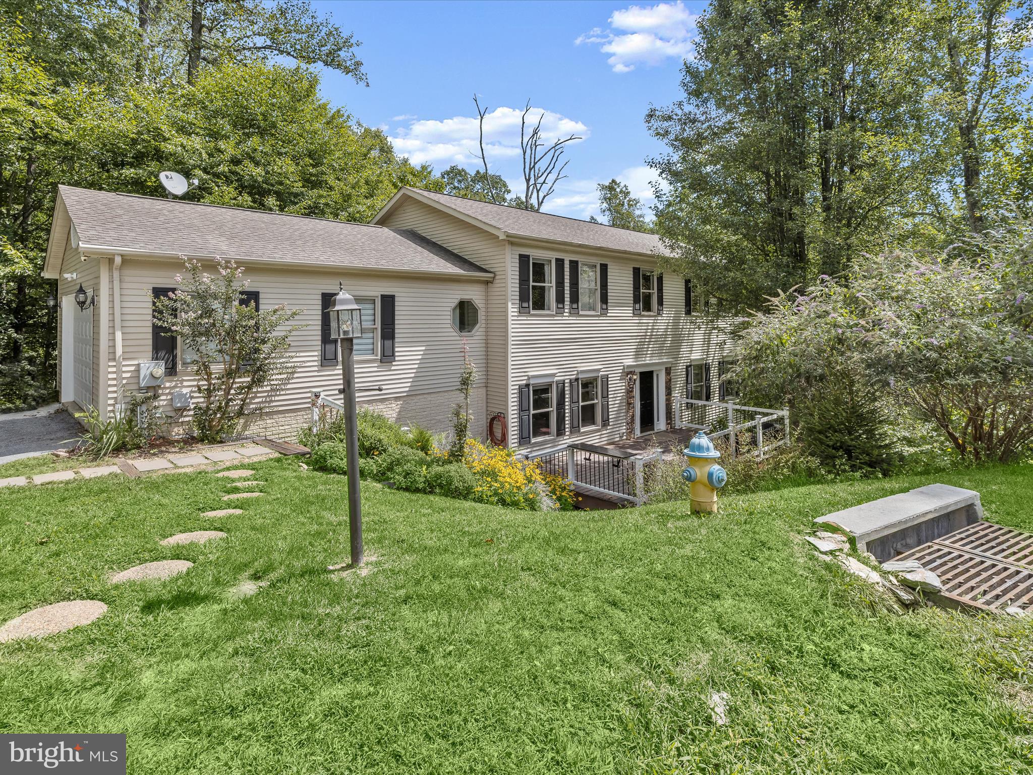 Escape to this wooded retreat tucked away at the end of a quiet cul-de-sac in the sought-after Woodridge neighborhood, offering four bedrooms and three and a half bathrooms across four levels. As you arrive, lush surroundings set the tone for the peaceful lifestyle that awaits, with a welcoming front porch to take in the views. Inside, the open main level is filled with natural light and features spacious living and family rooms for gatherings or everyday living. The eat-in kitchen includes a breakfast nook, pantry, and stainless steel appliances, while the adjacent dining room provides the perfect space for entertaining. A half bathroom and access to the two-car garage complete this level. Upstairs, the primary bedroom boasts an ensuite bathroom with a walk-in shower, soaking tub, and dual-sink vanity. Three additional bedrooms, a shared hall bathroom, and convenient laundry finish the upper level. The partially finished lower level offers a full bathroom and versatile bonus room, with even more potential to expand the living space. One level below, the unfinished basement provides ample storage. Enjoy greenery from every window and connect with nature outside, with views of Lake Marian and access to the Lake Trail leading to nearby Lake Linganore. All just a short 15-minute drive to downtown Frederick with quick access to Route 70. Some images have been virtually staged.