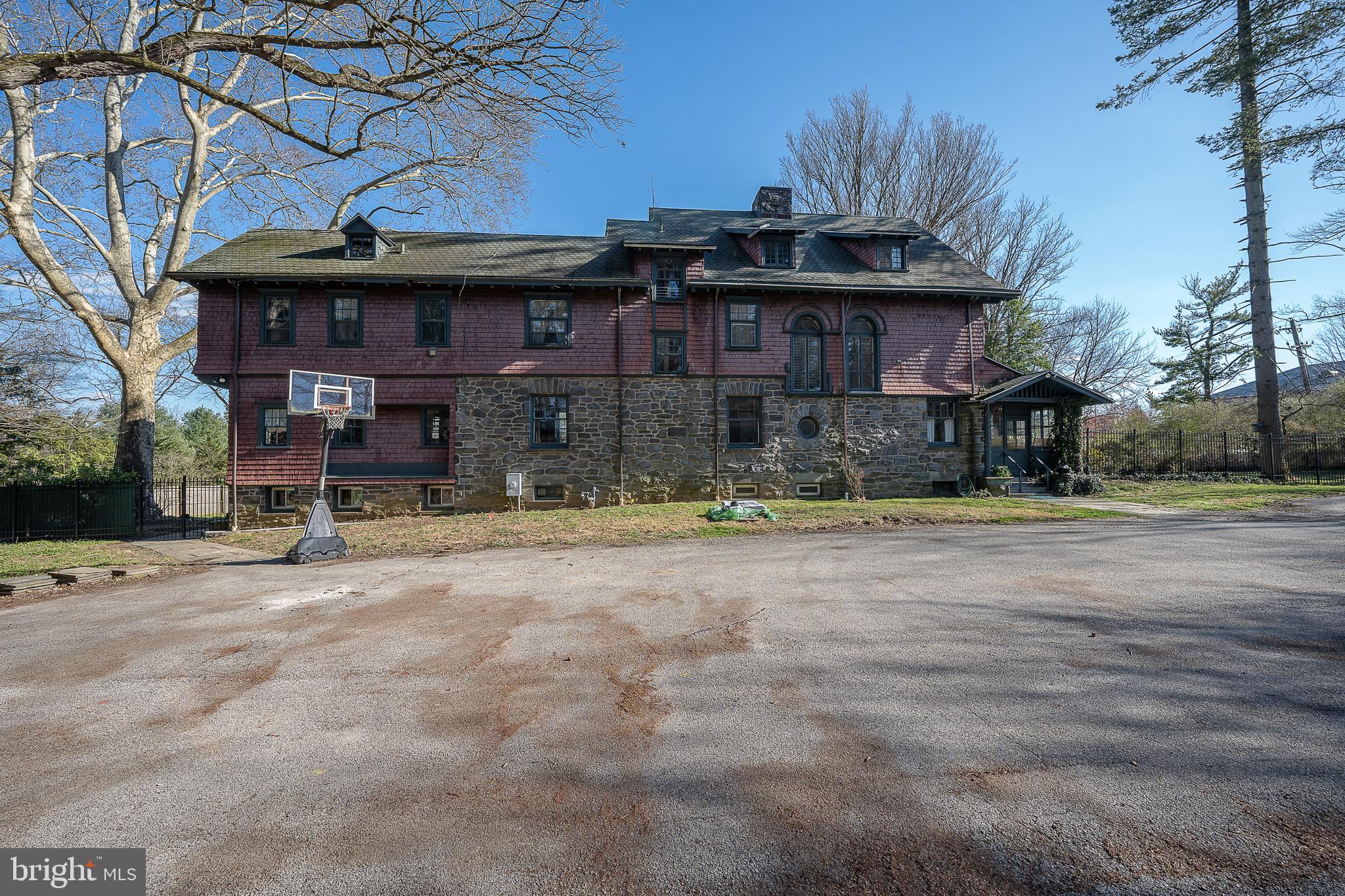 Situated on more than an acre of ground, this classic Main Line property features an impressive three-story stone home surrounded by stately trees, an expansive fenced yard, and a built in pool. This solid home is ready for a new owner to bring it back to its full grandeur. Preserved original detail and elements throughout such as such as 5 panel sold wood interior doors and original butler pantry cabinetry offer timeless appeal and add to the character that will anchor the old with the new as updates are completed. A glass vestibule on the right side leads to the charming Dutch Door providing access in characteristic old world style. The welcoming Foyer with corner stone Fireplace and its wide main staircase that guides you to the second floor landing with windows along the front of the house allows an abundance of natural light into both the first and second floors. The Foyer also houses an elevator which was one of the first residential elevators installed on the Main Line and adds architectural interest as well as function. The spacious Living Room is on the right, straight ahead is a Powder Room on the left, the Butler Pantry which leads to the Kitchen and the Dining Room with French Doors opening to the yard. Beyond the Kitchen is a Family Room with exposed stone wall and a mudroom with outside access thru an enclosed porch. The informal area has two back staircases to the second floor, one from the Kitchen to the Main Second Floor and the other from the Family Room to a private ensuite Bedroom. The grand foyer staircase provides access to four nicely size Bedrooms as does the Kitchen Staircase. The Primary ensuite Bedroom is adjacent to a separate Bedroom through an arched Hallway, which currently houses a washer/dryer and built in cabinetry. Expanding the Primary suite into this Bedroom still allows for 4 nicely sized Bedrooms on the second level. At the top of the Main Stair Hall is an additional ensuite Bedroom with French doors that offer views overlooking the grounds and a fireplace. Down the hall is a Full Bath, an additional Bedroom as well as closed door access to stairs to the main level and third floor with high ceilings and very livable space. Three full Bedrooms, one with French doors that open to a covered balcony, a Bonus Room that functions well as a playroom, a finished storage area and a Full Bath complete this level. The Basement has walk-out access to the left side of the house and daylight windows. Newer Gas Heater and Gas Hot Water Heaters. 200 Amp Electrical Service. This Prime location provides convenient access to all major roadways. Walk to Villanova Regional Rail and Trolly Stations, Shopping and Restaurants, or a close drive or use the train to enjoy Dining and Shopping in nearby Wayne, Bryn Mawr and Ardmore as well as Conshohocken. Property is Class 2 on Lower Merion Historic Registry.