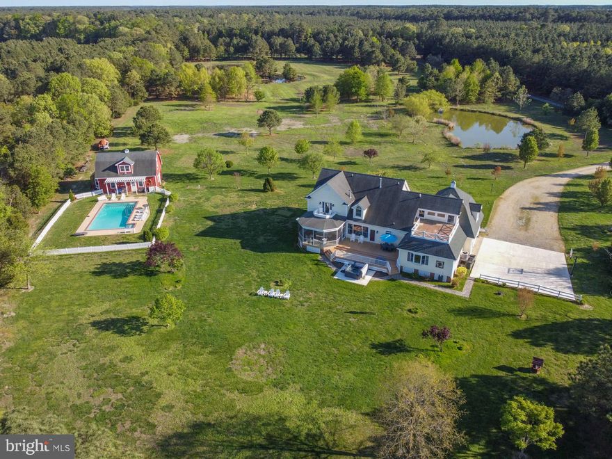 Coastal Living At Its Best! This Waterfront - William Poole design Cape has been tastefully professionally decorated and updated featuring high ceilings, hardwood floors throughout, beautiful kitchen with granite tops, SS Appliances, center Island, open concept, family room with gas fireplace, separate dining, living room and a private in-law suite on the first level that includes a kitchenette, living area, private bedroom and dedicated full bath. The second floor includes the Primary Suite with walk-out balcony, gas fireplace, walk-in closet and huge bathroom with tub, separate shower, double vanity. There is another bedroom with ensuite, and a large bonus room/game room. There is a large screened porch and deck on the water side. The 14+/- acre Property is improved with a picturesque barn and an inground gunite pool. The barn has a loft and new full bathroom to service the pool area. There is a waterfowl/wildlife pond and a large BIP pond, a pier with 1-2’ MLW, small beach with firepit area. House has been used as a vacation rental with income over $120K last year. Great investment, family retreat or primary residence.