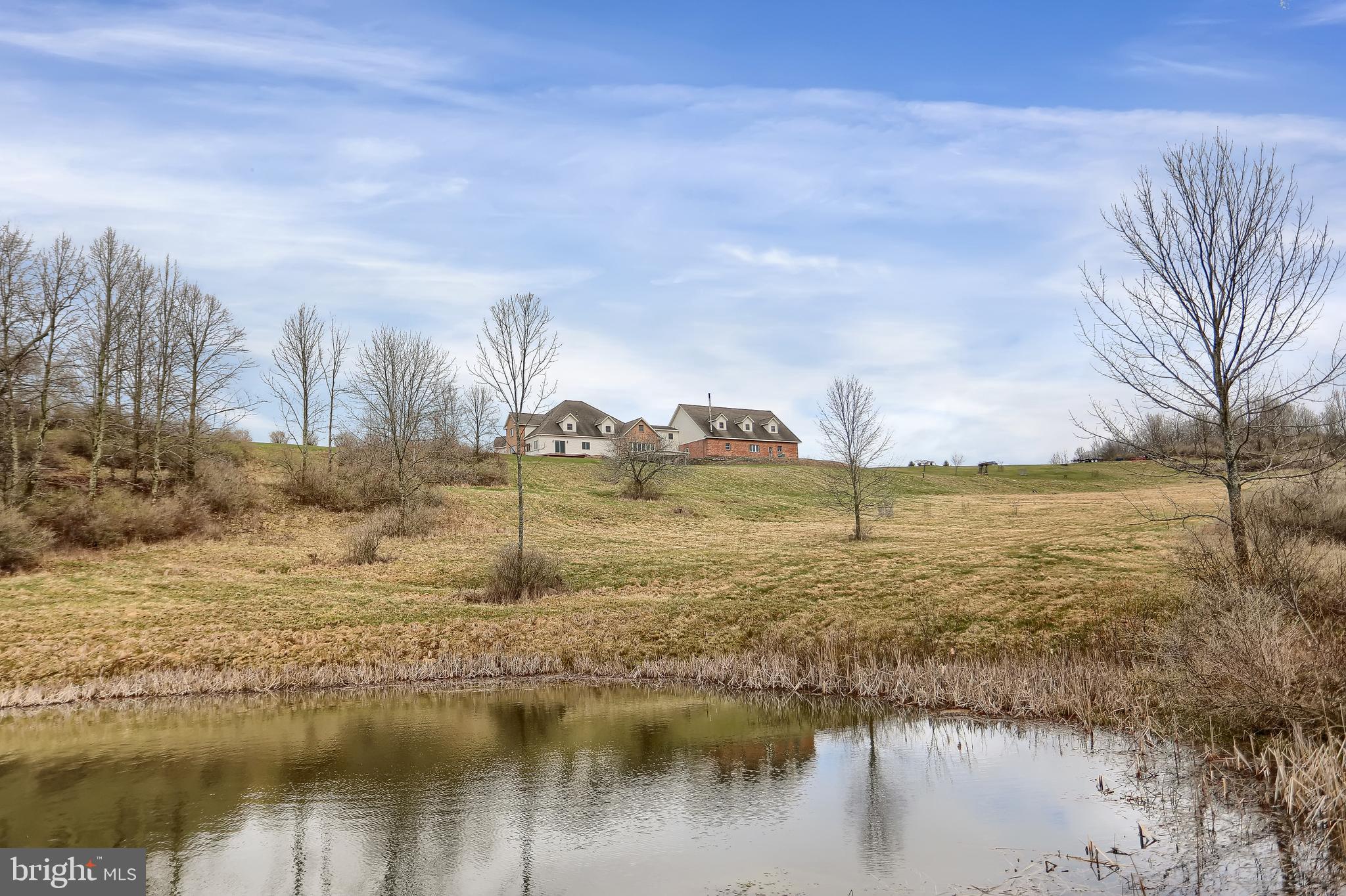 What a find! This 11,762 sq ft (including finished basement), home sits on 126.3 acres and would make a wonderful primary residence or a luxury Airbnb. The views from inside this 5-bedroom 6-bath home are awesome no matter where you turn. Looking out the floor-to-ceiling front window gives you a view of the Wellsboro valley and the back overlooks the pond, fields and woods. And you’ll want to keep that spotting scope handy as the wildlife is plentiful. There is a custom kitchen and master bedroom on the main level as well as a laundry, library, office, and oversized living room. The cherry hardwood floors lead to a large open staircase and the two large bedroom suites upstairs. In the daylight basement, you’ll find in-law quarters with a full kitchen, bath, laundry and two bedrooms, plus a large living area and rec room. This house was built with many high-quality materials like triple pane windows, non-chip plywood and 12” poured block (insurance appraisal put the replacement cost at over 3 million) and there is radiant heat throughout. Don’t let the cost of heating a big house deter you; a waste oil burner in the garage provides heat for everything at only $15/month. Natural gas provides a backup, and 3 energy efficient split units keep it comfortable in summer. The six-car garage has a room for a pickleball court or most anything that entertaining your friends would involve. The 70 acres of woodland has terrific hunting potential and mature timber. Nearby are many Tioga County attractions like the PA Grand Canyon, Pine Creek, bike trails and more. Whether you are looking for a dream home or the vacation spot to spend time with family, this will punch the ticket, so call today for a private showing!
