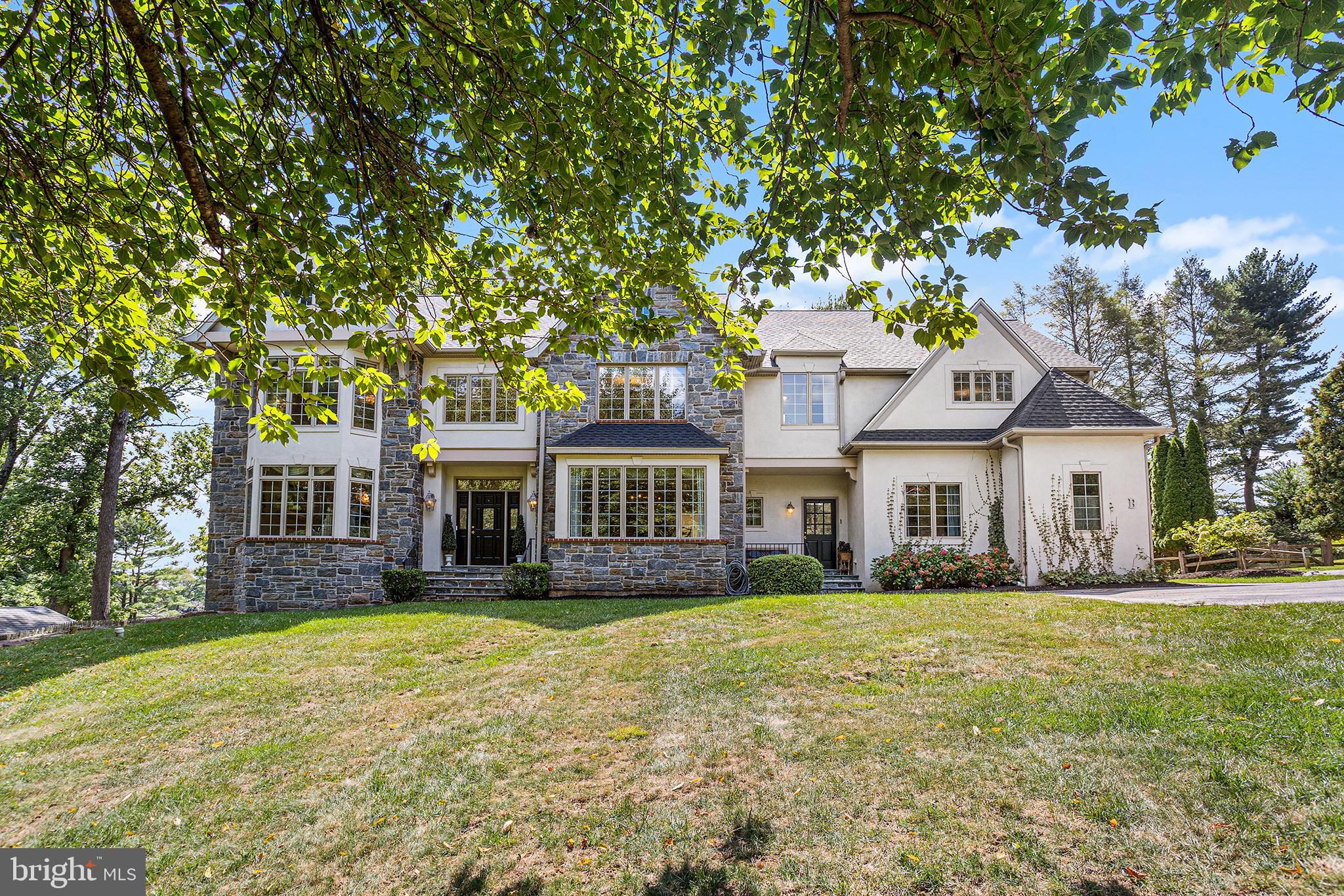 Showings start Wednesday September 10th. Set back from the road on a lush, private lot along one of Newtown Square’s most coveted stretches, 3408B Goshen Road radiates sophistication and bespoke luxury. This distinctive stone-front colonial commands attention with nearly $200,000 in thoughtful upgrades—showcasing a beautifully remodeled kitchen, designer lighting, artisan millwork, and custom built-ins. Step inside a dramatic two-story foyer and immediately feel the grandeur as you enter the gracious living room. Here, a striking marble gas fireplace is paired with a wall of soaring windows dressed in custom drapery, creating a light-filled sanctuary ideal for both intimate gatherings and grand entertaining. Across the foyer, the formal dining room captivates with detailed ribbon-inlay hardwood floors, elevated lighting, exquisite millwork, and prized front-yard views. At the heart of the home, the expansive, newly upgraded eat-in kitchen and great room offer the ultimate setting for family living and lavish entertaining. The chef’s kitchen boasts freshly painted custom cabinetry, all-new high-end appliances, a stunning quartz slab countertop and backsplash beautifully accented by a Greek key mosaic marble, and a massive center island with a secondary oven and bar seating. The sunny breakfast room seamlessly transitions into the great room, where custom built-ins, a gas fireplace, and oversized windows enhance the sense of volume and comfort. A sun-drenched home office, dual powder rooms, and a multipurpose secondary foyer with a laundry-mudroom provide everyday convenience and direct access to the oversized three-car garage—offering a seamless flow for busy, modern lifestyles. Upstairs, newly installed plush carpeting, elegant crown molding, and designer fixtures add a sense of refinement across every inch of the landing and bedrooms. The spectacular primary suite offers a tray ceiling, an inviting private sitting lounge or closet, and a spa-like ensuite bath featuring soaring vaulted ceilings, a walk-in glass shower, soaking tub, private water closet, and an additional walk-in closet. Four additional spacious bedrooms include one with its own lounge area and custom built-ins, while two chic jack-and-jill bathrooms offer generous proportions and timeless neutral finishes. The possibilities are endless in the oversized, walk-out basement with high ceilings—perfect for designing your dream home theater, gym, wine cellar, or playroom. Step outside to a resort-style flagstone patio and sprawling, professionally landscaped, and fenced backyard—an entertainer’s paradise that’s equally suited for relaxation and play. A new roof has just been installed and comes with a transferable lifetime warranty for lasting peace of mind .Located just minutes to dining and shopping at Ellis Preserve, this home offers easy access to commuter routes and esteemed local clubs, including Radnor Hunt. With a brand-new roof and comprehensive updates throughout, this pristine, move-in ready residence seamlessly blends classic architecture with the best of today’s luxury living. Created for the discerning buyer who values both style and substance, 3408B Goshen Road truly has it all.