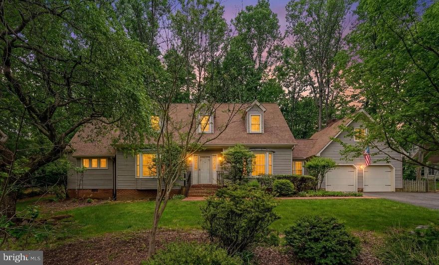 Sited on a gentle rise in the sought-after Hunton Wood neighborhood, this gracious 3-bedroom, 3.5-bath Cape Cod offers the rare combination of peaceful surroundings with daily conveniences nearby. Set on 1.37 acres backing to trees and protected common area, the home enjoys lasting privacy and tranquil views in a neighborhood known for its spacious lots and mature landscape.
A brick path leads to the front door and opens to newly refinished hardwood floors that flow throughout the main level. The living room, centered around a brick gas fireplace, connects seamlessly to the dining area. A bay window on one end and sliding glass doors on the other fill the space with natural light, while decorative beams add warmth and character. Across the foyer, a spacious library with built-ins creates the perfect work-from-home office or quiet study.
Daily life naturally gathers in the kitchen, which features updated appliances while retaining its original high-quality cabinetry. The adjoining breakfast area and large laundry room add convenience for everyday living.  Just beyond, a bright sunroom with vaulted ceiling offers a peaceful place for morning coffee or unwinding in the evening. Sliding doors lead to the patio and backyard, perfect for dining al fresco. 
The home offers three bedrooms, including a main-level primary suite with walk-in closet and a recently updated bathroom featuring a soaking tub. Upstairs are two generously sized bedrooms with new carpet and a full bathroom.
The lower level adds valuable living space with an updated bonus room featuring new carpet and paint, a full bathroom, and a wet bar, ideal for movie nights, game days, hobbies, or a fitness area. A large unfinished section provides excellent storage.
A detached outbuilding, long used as a woodworking shop, offers exceptional flexibility. Complete with a pellet stove for heat, a half bath, and an upper level, the space could easily transition to a studio, homeschool classroom, gym or garage.
Recent updates include new carpet (2025), whole-house generator (2024), roof (2024), pressure tank (2023), and windows (2016).
Ideally located in Fauquier County just off scenic Georgetown Road, the home is surrounded by rolling countryside dotted with horses and cattle, yet only 15 minutes west of Haymarket, offering the perfect balance of country living and convenience.