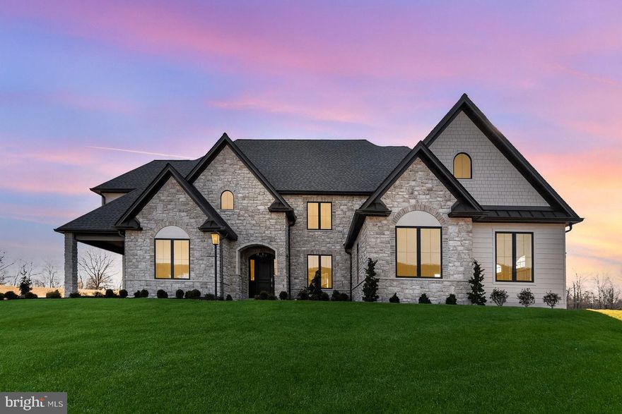 Another dream home in Glendale Estates, built by Musser Home Builders! This exquisite French Country–style residence showcases exceptional craftsmanship with thoughtful architecture, elegant details, and a layout designed for both beauty and function.
Step inside through a custom mahogany arched entry door and into the stunning Great Room, where a soaring 16’ vaulted ceiling with white oak beams, stone accent walls, and a grand gas fireplace set the tone for refined living.
White oak wire-brushed floors which flow throughout much of the home, lead you to a chef’s kitchen. This culinary space is equipped with an expansive center island, Thermador 6-burner propane range, 30” Panel Refrigerator & 18” Panel Freezer and dishwasher with cabinetry finish. An expansive working pantry includes a 2nd dishwasher and Bosch wall oven and microwave. For dining enjoy a beautiful custom banquette table for informal meals and a separate formal dining area with built-in Quartzite back lit wine bar including an undercabinet beverage refrigerator.
The spacious first-floor primary suite continues the home’s unique design, featuring exposed beams, a luxurious spa-like bath with custom tilework, soaking tub, walk-thru shower, quartz countertops, and a walk-in closet with built in organization.  Just steps away the main level generously sized primary laundry room offers custom cabinetry including crown molding, recessed lighting and an under-mount sink set in leathered granite counter workspace. The main-level office, with exterior access including it’s own private porch treat, custom built in lighted cabinetry, provides both privacy and style.
A lighted grand central staircase creates a dramatic focal point on the main level and leads to the second floor. At the top, an open loft with an adjoining powder room offers a versatile space for lounging, study, or play. The upper level also includes a large bedroom with en-suite bath featuring a dual vanity and walk-in tile shower, along with two additional bedrooms that share a generously sized Jack and Jill bath including a dual vanity sink. Completing this level is 2nd laundry room, thoughtfully designed with custom cabinetry, and leathered granite counters, bringing both convenience and luxury to everyday living.
Set on a large homesite, this property offers both privacy and room to grow. Outdoor living is a highlight, with a charming covered office porch that captures sweeping mountain views and a rear covered porch finished with a cedar ceiling and striking stone fireplace — perfect for gatherings year-round. The expansive lot also provides ample space to accommodate a future pool while still leaving plenty of room for entertaining and play. A side-entry three-car garage with carriage-style insulated doors and epoxy floors completes the design. As with every Musser home, energy efficiency comes standard, with Low-E glass windows, premium insulation, and a three-zone geothermal heating system. This remarkable home is sure to be the pride of Glendale Estates. Don’t miss your chance to make it yours!