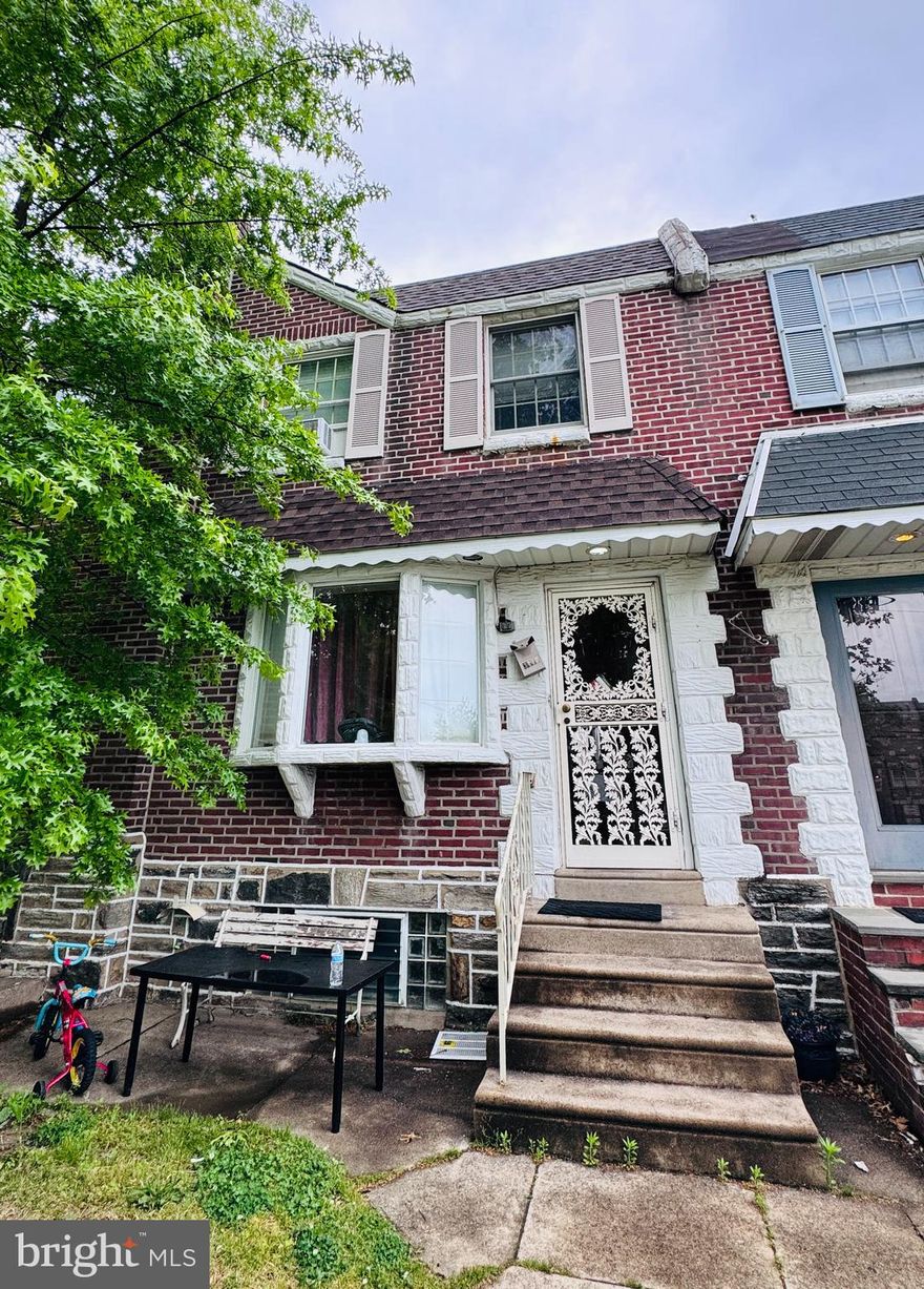 Welcome to this spacious 3-bedroom, 1.5-bath brick row-home located in the heart of Mayfair! Conveniently situated near supermarkets, schools, playgrounds, shopping, and public transportation, this home offers both comfort and accessibility.  Step inside to find a large living room with hardwood flooring, formal dining area, and an updated kitchen with ample cabinet space and access to a huge rear deck — perfect for entertaining, grilling, or relaxing outdoors.  The second floor features three generously sized bedrooms and a full bathroom with great natural light throughout. The finished basement provides additional living space, a powder room, laundry area, and direct access to the rear driveway and garage parking.  Great opportunity for both homeowners and investors alike!