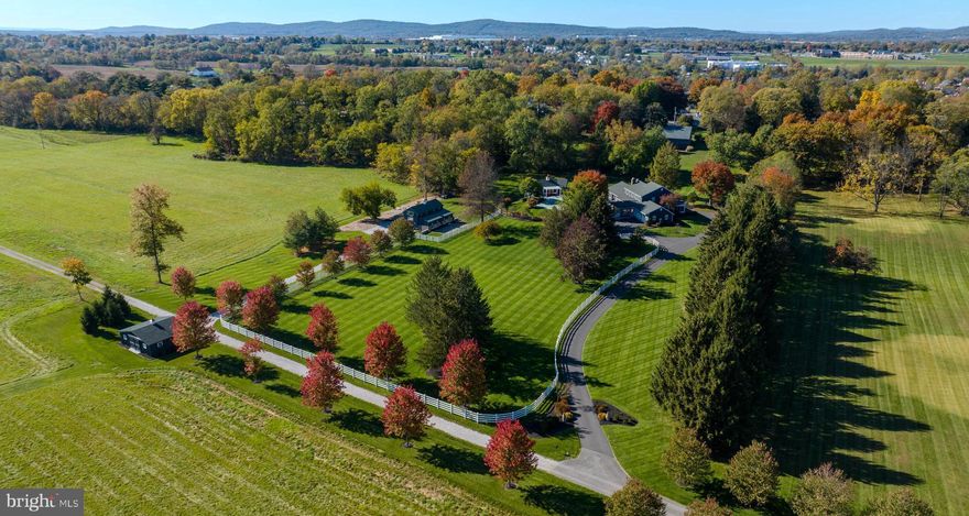Magnificent estate sitting on nearly 22 acres where you’ll enjoy peace and privacy in East Manchester Township, York County. Situated off a quiet, private lane, this unique property boasts a main residence, in-ground pool, pool house, party/hobby barn, and a horse barn/garage. Creating an enchanting feel are over fifty pear and red maple trees lining the entrance to the grounds. You will be captivated by the French provincial flair of the main house adorned by a redwood exterior. The interior is complemented by exquisite woodwork throughout and southern yellow pine floors on the main level. The kitchen is a chef's dream and hosts abundant cabinets, French limestone counters, a Jenn-Air gas stove, and Viking ovens. For formal gatherings, there are a large dining room and a great room complete with gas fireplace surrounded by soapstone and a grand coffered ceiling. A bright and cheerful sunroom provides the perfect spot to relax and unwind. The two-story foyer opens to a formal library hosting a brick woodburning fireplace and custom built-in bookcases crafted by the late renowned woodworker Carl Becker. Outside the foyer is a large screened-in porch perfect for peaceful reflection. The first-floor primary suite/private bath is a quiet retreat with a large window seat overlooking the pool area and picturesque patio. The fully finished lower level of the home houses a rec/game room, wine cellar, tasting room, gym, and sauna. On the second level, two bedrooms share a Jack & Jill bath and a third bedroom has an ensuite full bath. Moving outside, flagstone adorns the patio, the deck is made of mahogany, and the pool area is surrounded by porcelain pavers and granite coping. Beyond the pool area sits a 600 square foot pool house providing everything you need for enjoying warm summer days. From the outside dining area under the elegantly lit pergola to the fully equipped kitchen (including Wolf range and oven), living room/bedroom combination, and a full bath, this space is perfect for gatherings or for use as a guest house. A beautifully landscaped gravel path leads to the impressive two-story 1,900 square foot wood and stone monitor barn, rounded out with a rear loading garage. This versatile space can be used for entertainment, as an office, artist loft, guest quarters, or more. The party barn offers a full bath and a fully equipped kitchen highlighted by a six-burner, two oven commercial range and commercial dishwasher. Across the drive is a brand new 30 foot by 24 foot garage/horse barn with tack room currently utilized to store a vehicle and lawn equipment and could house up to three horses. Adjacent to the barn is a large fenced-in paddock, featuring a PVC white four rail fence. The property is enrolled in the Clean & Green program. Easy access to Route 30, I-83 and Pennsylvania Turnpike. Do not miss this spectacular estate offering resort-style living that is unmatched, combining elegance, quality, and serenity.