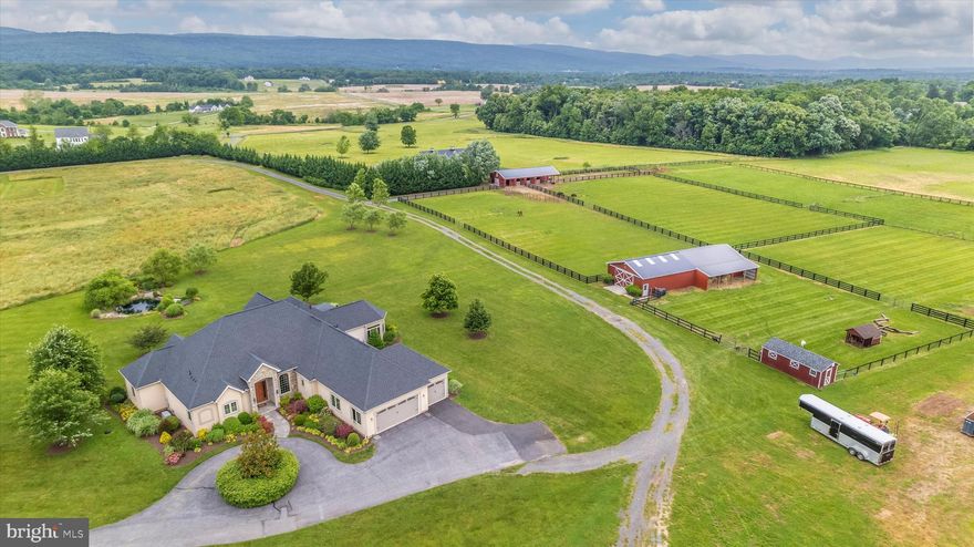 This is the absolute best of Frederick County! Bring your hobby livestock or your  agricultural business to this 25 acre property that is complete with stunning mountain views. The property conveniently  located minutes from  US 15 while still maintaining a very remote feel. This home is perfectly sited so you will never miss a mountainous sunset.  If the sun is not setting, you can still enjoy that view along with  the pastures and secluded open acreage in the foreground of those mountains from multiple rooms within the house as well as the elevated patio. 

Inside this home, you can find 5 bedrooms, 5.5 bathrooms and pure luxury throughout. Upon entering the front door you will be greeted by expansive ceilings that are carried throughout the home.  This is an open concept yet with defined spaces.  A more formal living room features a  gas fireplace. The open kitchen features light neutral cabinetry, dual pantries, granite countertops and an island w/ pendant lighting, wet bar and designated eat-in area.  Just off of the kitchen is an additional gathering space with gas fireplace, access to the back patio and more windows with picturesque views.  Off the living room is an all season room with sunken hot tub, another gas fireplace and neutral tiled floors.
There is a loft space above the living room with en-suite style bathroom and large closet perfect for guests,  in-laws, or a secluded office space. The main level primary suite features matching dual walk-in closets, a soaker tub, standing shower, dual vanities & a secondary attached room with (window & closet) ideal for a nursery or library/office. Two spacious bedrooms each with their own full bathroom are located down the hall along with the laundry/mudroom and additional storage closet. Here is where you can directly access the expansive 3 car attached garage. Lower level is partially finished with a living space as well as a bedroom and full bathroom all with fresh paint and carpet. Extended unfinished area is great for storage or can easily be converted into additional finished space. The outdoor space of this home must not be overlooked. The stunning elevated back patio features expansive stone work, remote control sun shades lengthwise of the entire patio, as well as a built in BBQ Grill. This is the ultimate home to entertain guests with this incredible outdoor living space. 

Exterior features of this property will not disappoint! If you are an agricultural enthusiast, you can find a fountain pond once used as an Equestrian Eventing bank water feature. Just steps away, the Shedrow style barn is charming with french doors directly accessing private turnout. Inside the barn you can find 4 stalls all equipped with automatic waters, a feedroom/tack-room combo and a completed wash-stall that could be converted back into an additional stall or supply you with access to a future extension to the barn. Enjoy roughly 5 acres of fenced turnout as well as dry lot options directly accessed from the barn. There is an additional Morton cement floored building with electric and water that has a recent extension for additional equipment/hay storage.  This structure could have many uses such as car collection and shop, equipment storage, additional staples and many more possibilities.   There are pastures that can directly access this building making it perfect for creating a run-in style shelter for additional livestock. The 100x200 outdoor arena has a bluestone base topped with extensive clay & sand mixture for ultimate drainage supplying a smooth ride year round.

FOR THOSE INTERESTED IN A MULTI-GENERATIONAL OR MULTI-DWELLING OPPORTUNITY THIS PROPERTY HAS DIRECT ACCESS BY ASPHALT PATHWAY TO MLS WHICH IS ALSO ON THE MARKET LISTED WITH SAME AGENT.