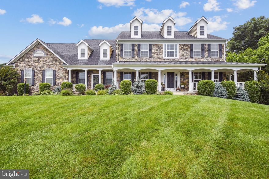 Stunning  single family home in sought after Evergreen Reserve with 3 finished levels over 6500 SF, 5 bedrooms, 4.5 bathrooms,  and a 3-car side load garage on a 1.16 acre lot!  An elegant stone front with stately dormers and a charming wrap around front porch, this home is uniquely located in a private enclave of homes offering a large cluster-maintained field in the front of the property.  Gleaming hardwood floors, a gracious two-story foyer and a gorgeous curved staircase with wrought iron balusters greet you at entry. Custom molding package throughout the home! The bright and open gourmet kitchen offers expansive cabinetry, granite countertops, center island breakfast bar with pendulum lighting, stainless steel appliances and large walk-in pantry.  The breakfast room leads to a composite deck overlooking the rear lawn with a beautiful tree-lined view in the distance.  Enjoy the integrated surround sound speakers both inside and out! The main level boasts a large family room with stone mantled fireplace, separate formal dining and living rooms, an office or playroom, powder room, and a large mud room & laundry room with built in cabinetry.  
The upper level has 4 spacious bedrooms, 3 full bathrooms and is accessible via dual staircases.  The primary suite offers a tray ceiling, sitting room, and enormous his & her closets - so large that one is used as an exercise area.  The primary bathroom includes dual separate vanities, shower and soaking tub. The 2nd bedroom is ensuite while the other 2 bedrooms share a jack and jill bathroom with a double vanity and separate shower/lieu.
The lower level is perfect for entertaining!  Fully finished with tons of natural light, this walk-out recreation area leads to a stone patio with a built-in grill and woodburning fireplace.  Playground conveys! A stylish full bar with gorgeous granite countertops & cabinetry, wine fridge, additional dishwasher and pendant lighting.  The 5th bedroom, 4th full bath (both ADA compliant), and two multi-purpose rooms complete this level - possible 6th and 7th bedroom, additional office space, exercise room, media room...so many options!  Large multi-purpose room and Rec area are pre-wired for Movie room. Ample storage too!
This property is conveniently located just minutes from Brambleton Town Center and the soon to be open Silver Line Metro. Enjoy all that Loudoun County has to offer!