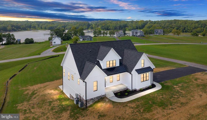 Brand new and move-in ready! This stunning craftsman-style water-access home, built by Hawkins Custom Homes is move in ready and comes with a deeded boat slip (#4) in the nearby common area directly across the street—just a short walk away. Perfectly situated on the public side of Lake Anna in the peaceful Lands End Subdivision, this retreat offers gorgeous lake views, a serene 1.72-acre corner lot, and an unbeatable location less than two hours from Northern VA & DC. By boat or car, you’re only minutes from Tim’s at Lake Anna, MooThru ice cream, Below Deck LKA, mini golf, The Cove, and more! Inside, you’ll find over 4,200 sqft of upgraded living space across three levels, designed for both comfort and entertaining. The open-concept main level features coffered ceilings, LVP and tile flooring, quartz countertops, stainless steel appliances, Marvin windows with black trim, board-and-batten siding, and more. The main-level primary suite offers a walk-in closet, tile shower, soaking tub, and dual vanity. Upstairs offers three spacious bedrooms and a full bath. The massive finished walkout basement provides endless possibilities with a family room, living room, rec room, movie room, bedroom, full bath, and utility room. Additional highlights include dual-zone HVAC, paved driveway, and a 2-car attached finished garage with a 16x8 insulated door plus hot and cold water. Outdoor living is a dream with a covered front porch, screened-in porch overlooking the lake, and a concrete patio—perfect for morning coffee or evening gatherings. Short-term rentals are permitted, making this an ideal investment or personal retreat. This home truly has it all—modern design, luxury finishes, water access, gorgeous lake views and a prime location. Come see for yourself and fall in love with Lake Anna living!