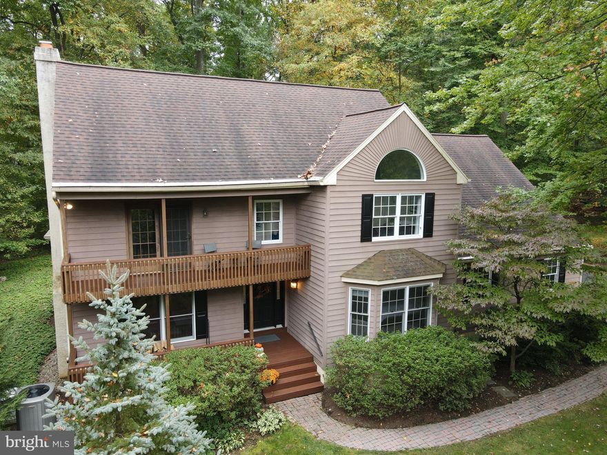 This stunning custom home is set on a peaceful 2.5-acre wooded lot, bordered by over 1,000 acres of state game land, providing spectacular views from nearly every window. Tucked away in a private cul-de-sac, the property boasts beautifully landscaped grounds, raised garden beds, an expansive driveway, a side-entry garage, and a welcoming covered front porch. As you step inside, you’ll find exquisite hardwood flooring that flows throughout much of the main level. The spacious sunken living room features a cozy wood fireplace, an open beam ceiling, and elegant wood accents. Adjacent to this area is a breathtaking sunroom, recognized as the Room of the Year in the 2007 Parade of Homes. With French doors, two skylights, and recessed lighting, this versatile space can serve as a serene retreat or a lively playroom.  The sunroom seamlessly connects to the dining area, which includes a charming bay window and a custom window seat. The well-appointed cherry kitchen, with 48 cabinets, offers generous counter space and a large pantry. Conveniently located near the kitchen, a sizable laundry room and half bath provide additional storage. The first-floor master suite is a true sanctuary, featuring a bay window, built-in cabinets, a walk-in closet, and a luxurious en-suite bathroom with a jetted tub, dual sinks, and a stall shower. Upstairs, you’ll find three spacious bedrooms, each with unique bi-fold closets made from solid oak. The largest bedroom includes extra storage and could serve as a second master suite, with French doors leading to a 22-foot balcony. The additional two bedrooms have vaulted ceilings and plenty of natural light, one with a large picture window and the other with skylights. This level also includes a full bathroom with tile flooring and skylights. The oversized two-car garage features a fully framed second floor, ready to be transformed into an additional 500 square feet of living space—ideal for an in-law suite or mini apartment with its own entrance. Out back, a large flagstone patio, stone wall, and grassy area create a beautiful outdoor space that blends into the tranquil woods. The home is equipped with surround sound and a whole-house GENERAC generator with an automatic 8-second kick-on, ensuring reliable power. Recent upgrades include a new high-efficiency heating and cooling system, a newer roof, and an updated well and neutralizer. Conveniently located near Route 10, Route 422, Route 176, and the PA Turnpike, this exceptional property is truly unique and won’t be on the market for long!