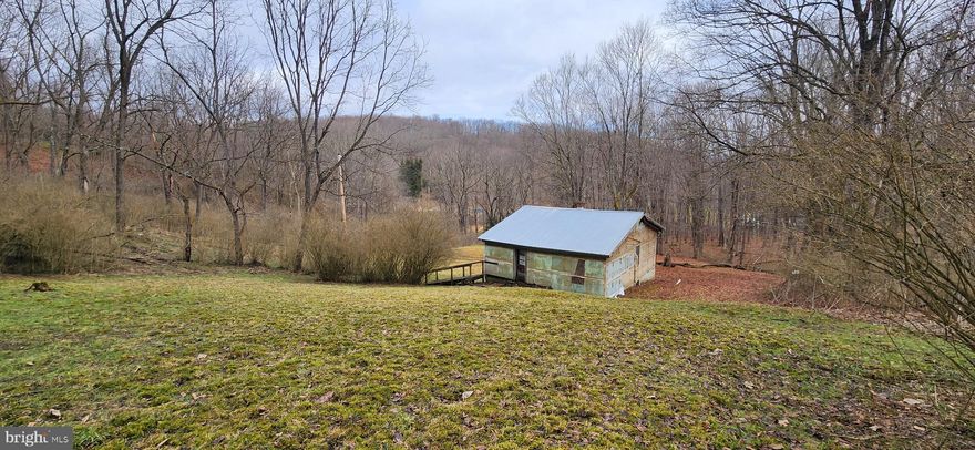 Over 5 acres surrounded by forest and adjacent to a mountain stream,   1 mile from Youghiogheny River & white water haven of Friendsville. This is an ideal spot for a mountain retreat; a peaceful setting surrounded by mature trees and just enough cleared lawn area, listening to the water cascading down the mountain just a stones throw away. Right of way access from Dixon Rd, spring water, and electric in place.  The house is believed to be a teardown though foundation and metal roof could be repurposed/salvaged. House has visible wood rot and decay. DO NOT ENTER. Sold AS-IS.