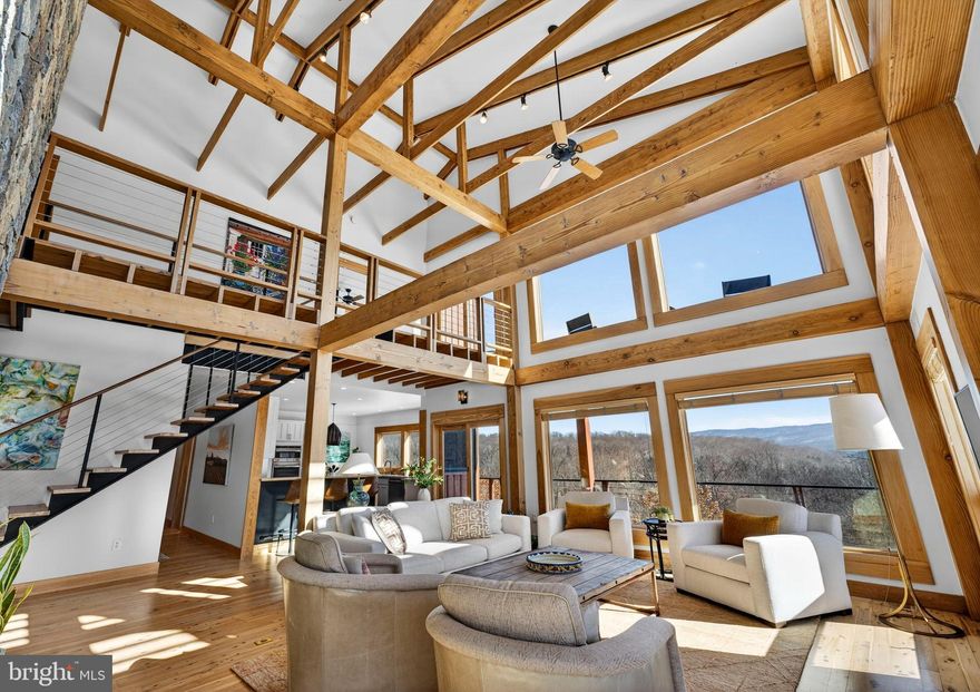 America’s poetic natural beauty includes the Blue Ridge Mountains and the Shenandoah River. Cross the mountains, the horizon widens, the landscape opens and tension starts to fade.  Here is where you will discover The Clearing at Chilly Hollow, a most private site and a home of striking design, one hour from the Nation’s Capitol.  A sanctuary, an adventure, a family retreat. 
*Please do not drive up driveway without an appointment*
Positioned on a sunny plateau surrounded by 70 acres of private woods, the circa-2000 custom cedar home of 5,190 finished sq ft., has architectural presence that equals its natural surroundings, with significant updates throughout. 
A wall of windows in the 2-story Great Room frames expansive Blue Ridge views, balanced by a floor-to-ceiling stone fireplace, beneath exposed beams and rafters. The staircase, a design feature unto itself, completes the modern, minimalist mountain retreat aesthetic. The great room flows into the updated kitchen and formal dining room. A generous library with custom built-ins and its own stone fireplace easily flexes as a fourth bedroom, with a new full adjacent bath. Refinished hickory hardwood floors extend through the main and second level. Upstairs, a light-filled primary suite enjoys 180-degree views.  With newly added hardwood floors and a stunning ridgeline vista, bedroom 2 shares a Jack-n-Jill bath with the 3rd bedroom.
The fully renovated lower level provides a bright gathering space for games and fitness, with direct access to the large saltwater heated pool and 2025 hot tub.  Pool parties are a breeze with the new kitchenette, half bath, and premium waterproof flooring.  Outdoor living is seamlessly integrated throughout. A wraparound main-level deck leads to the pool, while the new upper deck feels like a treehouse, a magical perch stargazing or watching wildlife. The screened porch, often a favorite gathering spot, is ideal for alfresco dining. Decks are constructed with Brazilian Ipe hardwood for enduring performance.  A dedicated-entry bonus space or office supports working from home with high-speed Starlink and Ethernet connectivity.
Outdoors, the land is a private playground. A 4 mile network of trails lead to Dog Run, a strong creek perfect for wading and respite. The new commercial-grade, oversized pickleball court offers tournament-quality play or a quick game before dinner. A 5-acre disc golf course weaves through the landscape. The Shenandoah River, just a mile away with boat launch, opens up kayaking, fishing, and endless river days.  A fenced garden with raised beds, a large detached garage, and storage barn accommodate hobbies, projects, and everything in between. A Generac whole-house generator offers peace of mind.
The Clearing at Chilly Hollow in Clarke County near hiking destinations of Ravens Rock, Cool Spring Battlefield, Bear’s Den, and the Appalachian Trail.  Wineries and breweries like Dirt Farm Brewery and Bluemont Vineyard dot the area. Superbly located with quick access to Route 7, 30 minutes to Leesburg, and just an hour to Washington DC with only one stoplight in between.