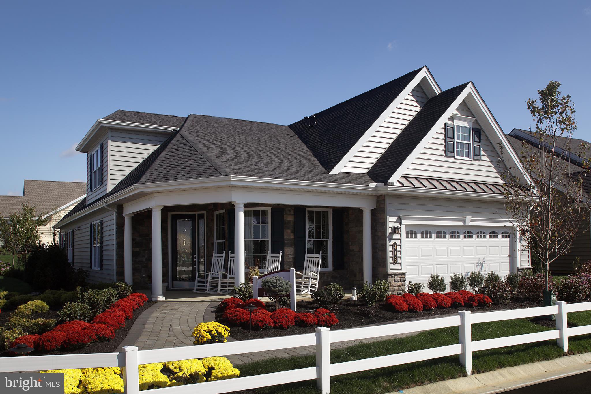 Live Better in a Designer Model Home at Traditions of America at Lititz 55+ Resort Lifestyle community. The Lincoln is designed by one of America's best 55+ architects and is only steps from the National award-winning Clubhouse with sports bar, fitness center, outdoor pool, tennis and more! A columned, wrap-around front porch creates a distinctive facade. This grand home impresses with soaring ceilings enhanced by wood beams & stunning trimwork throughout. The Gourmet Kitchen boasts crisp white cabinetry with glass inserts & matching range hood complemented by Absolute Black granite countertops and chic black appliances. A two-story Great Room showcases a stone fireplace surrounded by beautiful palladian windows. Relax in the oasis of the Owner's Suite featuring a spa-like Bath complete with 7' tiled steam shower. Entertain indoors or out with a built-in bar in the Great Room and expanded paver patio with 18" sitting wall. Say goodbye to mowing & shoveling and hello to your new lifestyle!