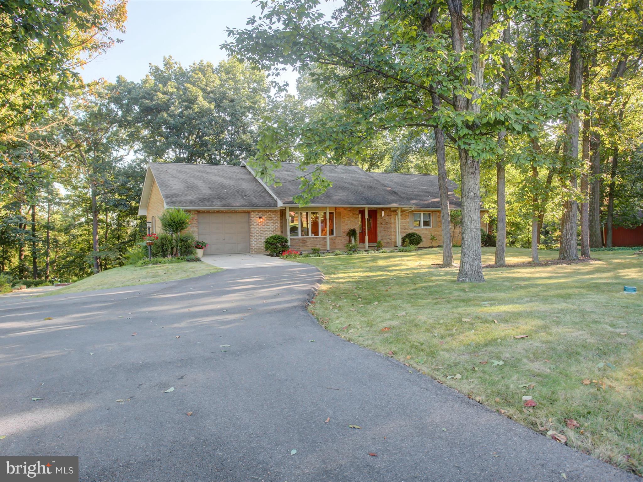 Discover this all-brick raised rancher tucked away on a private, wooded one-acre lot—just minutes from town yet offering the peace and privacy for which you have been dreaming!
Inside, the spacious gourmet kitchen is sure to impress, featuring an abundance of cabinet space and an oversized island that makes cooking and entertaining a breeze. The main level offers comfortable living areas and generously sized bedrooms, including a primary suite with double closets and a private bath.
Downstairs, the finished walk-out basement is a true retreat with a cozy family room, highlighted by an all-brick wood-burning fireplace, built-in shelving, and even a working phone booth for a touch of fun and character. Just off the family room, you’ll find an additional recreation space—perfect for a home theater, playroom, or hobby/craft room.
This home also features a versatile studio apartment/in-law suite, complete with a small kitchen and full bath with a walk-in shower—ideal for extended family, guests, or even rental potential.
The level backyard offers a wonderful spot for a garden to flourish, while a cozy patio and firepit create an inviting space to relax and enjoy the outdoors. Storage will never be an issue, with ample space in both the attic and the basement. Combining privacy, convenience, and thoughtful design, this home is a rare find that checks all the boxes.