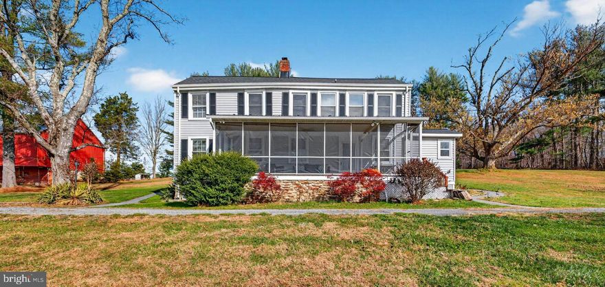Value-add opportunity with substantial equity upside. This home is priced to reflect needed updates and presents an excellent chance for investors or savvy buyers to renovate, reposition, and capitalize on the strong resale potential.  Seize a rare opportunity with this livable yet decidedly original 11.2-acre property/farmette, privately situated in a gorgeous location. This property is a true diamond in the rough, offering tremendous potential for buyers ready to infuse it with modern style and personalized updates. 
Enjoy peaceful country views and the quiet privacy this setting affords from the expansive screened-in front porch, a wonderful spot for morning coffee, overlooking a picturesque pond and rolling countryside. The existing home offers a classic, functional layout, though it retains the charming character of its vintage and is ready for cosmetic improvements throughout. The main level features: A spacious living room, dining room, kitchen that is functional but ripe for a full renovation, a practical mudroom, a cozy family room with a wood-burning fireplace, full bathroom with a walk-in shower (updated in 2022) with access to the wrap-around patio. Upstairs, you’ll find three bedrooms, a versatile den/office, and two additional full bathrooms, which are clean and serviceable, yet reflective of the home's older era. The exterior features a brand new roof and siding. The Property: Endless Possibilities The true standout here is the incredible infrastructure: Oversized Bank Barn: Recently enhanced with new garage doors (with keypad access) and a brand-new roof (to be completed by 12/17/2025). The generous upper-level storage is ideal for hay, vehicles, tractors, or boats, while the lower level features four large stalls and an open front area. Additional Outbuilding: A separate one-car garage/outbuilding. Farm Features: Includes a tranquil stream, fenced paddocks, and sweeping country views—all perfectly set up for equestrian or farm life. This property provides a fantastic foundation and is ready for its next owner to polish it up and unlock its full potential. Bring your contractor, your design ideas, and your dreams.