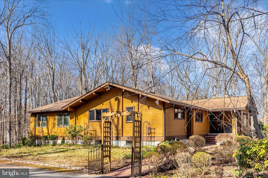 Tucked away on 5.29 private wooded acres in Mount Airy, this truly one-of-a-kind property offers the perfect blend of rustic charm, space, and versatility. This 6-bedroom, 3.5-bath Western Red Cedar cabin with a large traditional-style addition is anything but ordinary. From the moment you step inside, you’re greeted by dramatic soaring ceilings, warm cedar finishes, and custom touches throughout. The exterior cabin walls are double-course construction totaling over nine inches thick, providing exceptional insulation and efficiency. The main living level features five bedrooms and 2.5 bathrooms, offering flexibility for family, guests, or home office needs. The kitchen has been updated with newer appliances, making it both functional and inviting for everyday living and entertaining. Major systems have been thoughtfully maintained, with the roof, water heater, heat pump/HVAC all under four years old, giving buyers added peace of mind. The fully finished lower level includes a sixth bedroom, full bath, workshop, living room, kitchenette, and separate laundry area. Registered as an apartment with its own address and private walkout access to an additional parking area, it’s ideal for multigenerational living, guest quarters, or potential rental income. Step outside and you’ll find even more to love. Two barns add incredible functionality, including one with a finished upper level perfect for gaming, hobbies, or unforgettable sleepovers. Multiple picnic and gathering areas create inviting spaces for entertaining and making memories. The rear three wooded acres are an outdoor enthusiast’s dream, featuring established hiking, go-kart, and ATV trails with endless loops, curls, and branches for year-round adventure right in your own backyard. To make maintaining and enjoying the property even easier, a UTV equipped with a plow and leaf sweeper is included with the sale. The home is equipped with an emergency generator, cable TV, internet, and landline service, and the gutters have been recently upgraded with a LeafFilter system—meaning no more gutter cleaning. If you’ve been searching for privacy, character, space, and a property that truly stands apart, this Mount Airy retreat offers a lifestyle that’s hard to find and even harder to leave.