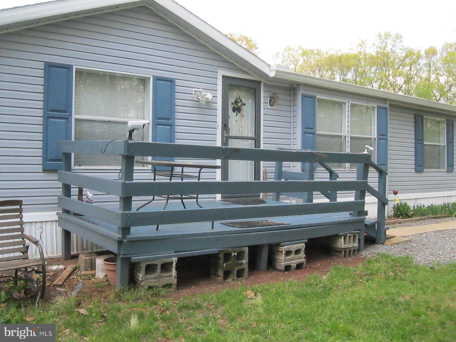 Here is the convenience of mobile home living without the confining atmosphere of a mobile home park. This home is in a small neighborhood of approximately 10 similar homes in a rural location. There are woods on two sides of the lot with the quiet, shade and wildlife you would expect in this setting. You will find the inside to be very spacious and comfortable. The combination living room and dining area has a stone gas fireplace and large windows. The 32 handle kitchen has stainless steel appliances and a picture window looking out to the woods. There is an adjoining laundry room. This end of the house includes the master bedroom and bath and another room, accessible from either the kitchen or bedroom which would make a nice office , nursery or private sitting room. On the opposite side of the living room is a hallway leading to three bedrooms and a full hall bath. A large closet in the hallway houses the upright freezer. The ground rent of $340 a month includes water and sewer from community systems and trash removal.