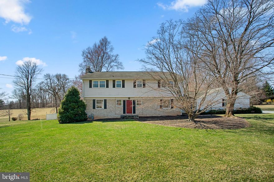 Charming Colonial residence spanning 4,008 square feet with 5 bedrooms, 3 full baths, and 1 half bath in picturesque Sunnybrook Farms, adjacent to Soldiers Delight Natural Environment Area for a serene setting. A beautifully landscaped front yard and expansive driveway set the stage for this inviting home, which blends farmhouse-inspired rustic charm with a traditional floor plan. 

Step into the foyer, where classic brick flooring and an elegant powder room welcome you. Hardwood floors flow throughout the main level, enhancing a spacious living room with a wood-burning fireplace, an exposed brick wall, and striking exposed solid wood beams, as well as a cozy study with built-ins. The fully remodeled gourmet eat-in kitchen features an island breakfast bar, granite countertops, exposed solid wood beams, ample white cabinetry with glass-front accents, open shelving,  a built-in wine rack, a charming tile backsplash with floral detailing, and an adjoining dining area with deck access for seamless indoor-outdoor entertaining. A spacious laundry corridor leads to a private in-law suite, complete with a separate exterior entrance, a great room, a full kitchen, a bedroom, and a full bathroom—providing a perfect retreat for guests or multi-generational living. 

Upstairs, four generously sized bedrooms with hardwood floors are complemented by two full bathrooms, including the primary suite with a walk-in closet and an en-suite bath. The lower level offers a bright recreation room with a wood-burning fireplace, a versatile bonus room with walk-up exterior access, and a utility room for extra storage.

Outside, enjoy the expansive open lot, a covered patio off the in-law suite, a spacious deck, and a fully fenced, flat backyard with 2 storage sheds and breathtaking countryside views.
