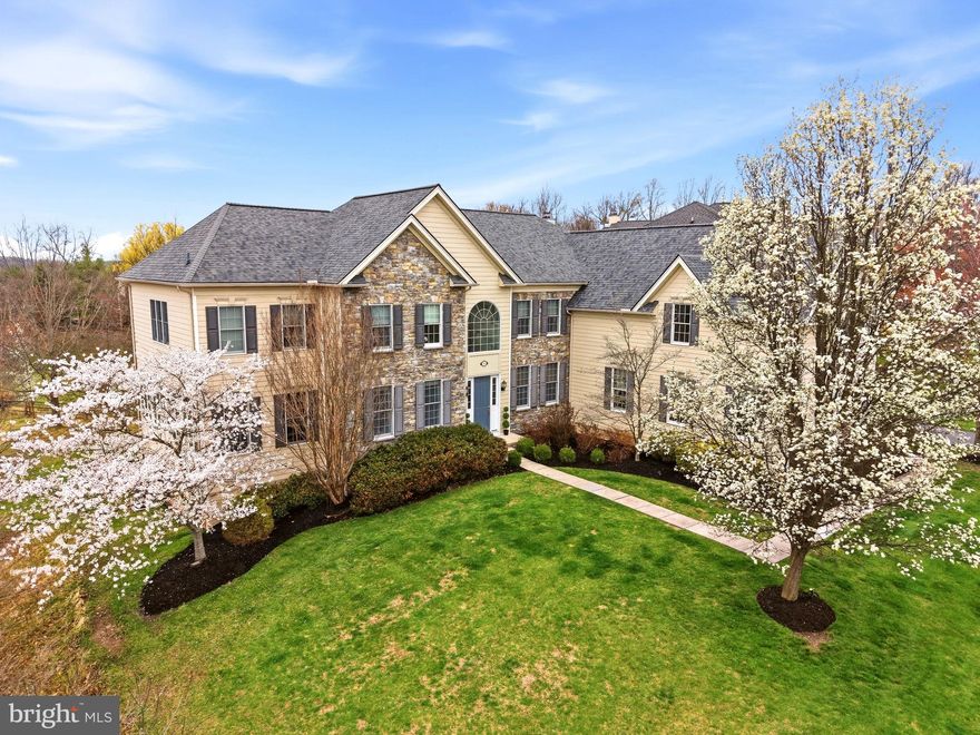 Welcome to 9 Goldfinch Circle, a beautifully appointed home in a prime location in the estate section of Rivercrest—an exclusive, gated enclave within this highly sought-after community. This spectacular five-bedroom home offers three beautifully finished levels of living space and backs to protected community open space. A dramatic  two-story entrance hall with a turned staircase and elegant wrought iron railings sets the tone. To the left, a gracious living room with custom decorative wood flooring flows seamlessly into a dramatic conservatory filled with natural light from walls of Palladian windows and accented by custom tile flooring. A well-placed wet bar connects these spaces to the dining room, creating an ideal layout for entertaining and holiday celebrations. The heart of the home is the gourmet kitchen which features a large granite island with pendant lighting, extensive counter space, raised-panel cabinetry, tile backsplash, stainless steel appliances, display cabinetry, and a huge walk-in pantry. The kitchen opens to a large dining area and a fabulous sunroom addition—perfect for morning coffee or quiet relaxation—with direct access to the low-maintenance deck overlooking the rear grounds and open space. The adjacent family room is breathtaking, highlighted by a vaulted ceiling, walls of Palladian windows, a floor-to-ceiling stacked stone gas fireplace, and direct deck access. A nicely sized home office is tucked away just off the entrance hall, as is a tiled powder room. A perfectly situated mudroom with built-in cubbies leads to the oversized three-car garage. A sunny, cheerful laundry room completes the picture for the first floor of this wonderful home. Upstairs, a gracious landing leads to the luxurious owner’s suite, complete with a large sitting area, two custom tremendous walk-in closets, dual vanities, a separate make up area, and a spa-like bath with a jetted tub and oversized tile shower. The second and third bedrooms each enjoy their own en-suite bathrooms, while bedrooms four and five share a Jack-and-Jill style bath. Bedroom five is an open and airey space, perfect as a guest suite, home office, or upper-level family room/den. The finished lower level provides a great deal of additional living and entertainment space, including a large family room, media alcove, fully equipped wet bar, and direct access to the rear grounds. Another two finished rooms offer endless possibilities. A gym area, a full bathroom and a huge massive storage room with built-in shelving complete the lower level of this incredible home. The outdoor space of this home is a cut above the rest. The huge rear deck is the perfect setting for relaxing, entertaining, grilling, or dining al fresco while enjoying tranquil views of the surrounding natural open space. Beautiful hardwood floors, custom window shutters, tons of closet and storage space, walls of windows, soaring ceilings, and an open concept floor plan blend nicely to create a wonderful living environment. Exceptional craftsmanship, exquisite detailing and thoughtful upgrades all come together to make 9 Goldfinch a very special place to call home. Set in a prime location within the sought after gated community of Rivercrest. Residents enjoy access to outstanding amenities including a pool, tennis courts, a fitness center and the opportunity to join the Rivercrest Golf Club. This is an extraordinary opportunity to own a truly special home in one of the area’s most desirable neighborhoods. Your search is over—welcome home.