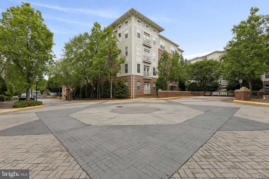 Walk to the Vienna Metro from this highly desirable corner unit filled with natural light from multiple windows and thoughtfully positioned for added privacy; this spacious approximately 1,250 sq ft condominium offers an open-concept layout ideal for both everyday living and entertaining, featuring wood flooring throughout the main living areas and bedrooms, a generously sized primary suite with an expansive walk-in closet, and a charming Juliet balcony, along with ceiling fans, in-unit laundry, and a well-designed kitchen complete with a center island and Corian countertops; enjoy peaceful, unobstructed views year-round, with lush greenery in the summer and broader lake vistas in the fall and winter; conveniently located just steps from the elevator, the unit includes one assigned underground parking space and a guest parking pass, and residents benefit from easy access to I-66, Route 123, and Route 29, plus proximity to Nottoway Park and an array of community amenities including a basketball court, outdoor pool, clubhouse, fitness center, billiards room, business center, and golf simulator.